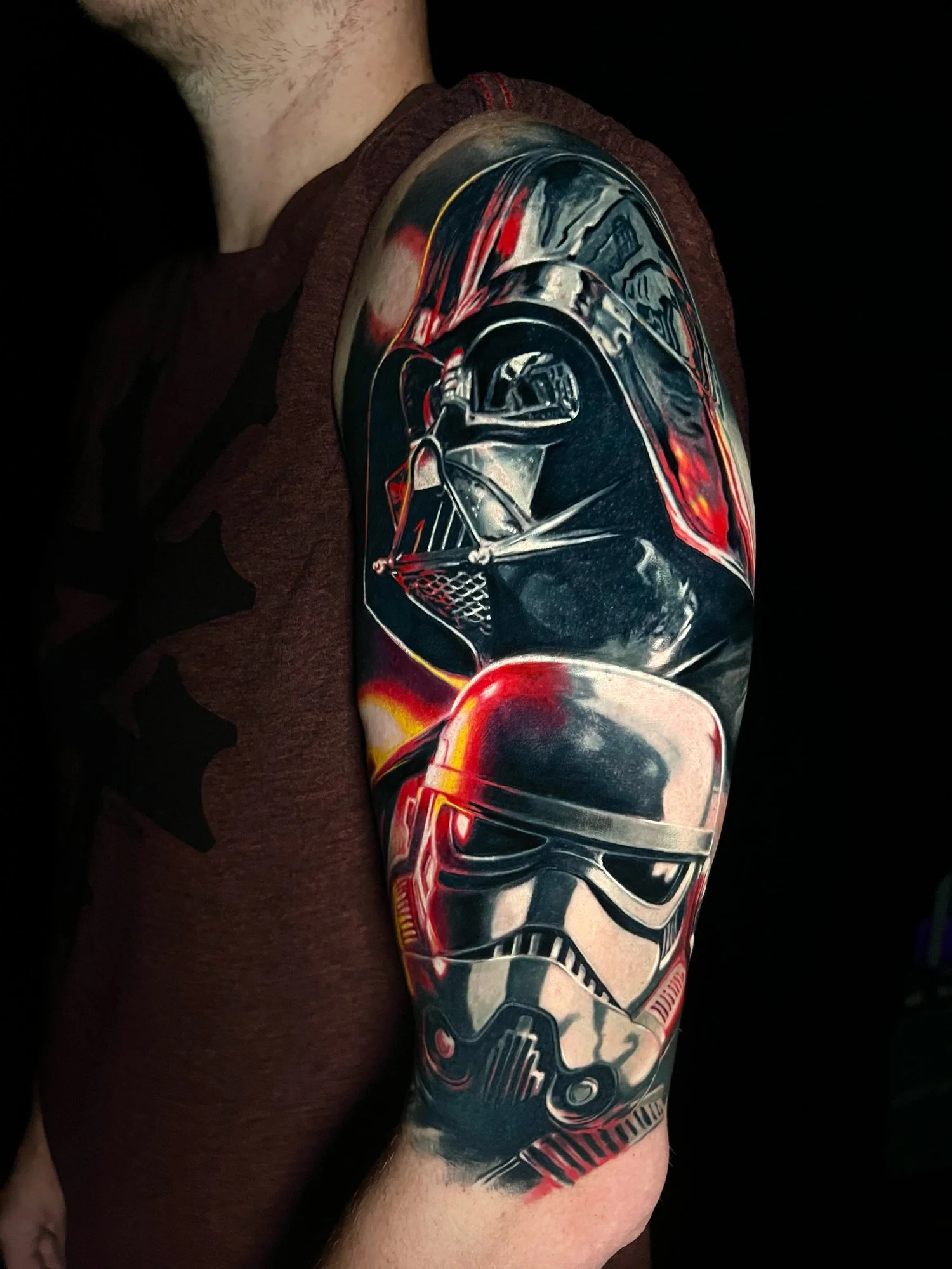 Tattoo of Darth Vader and a Stormtrooper helmets from Star Wars on person's arm.