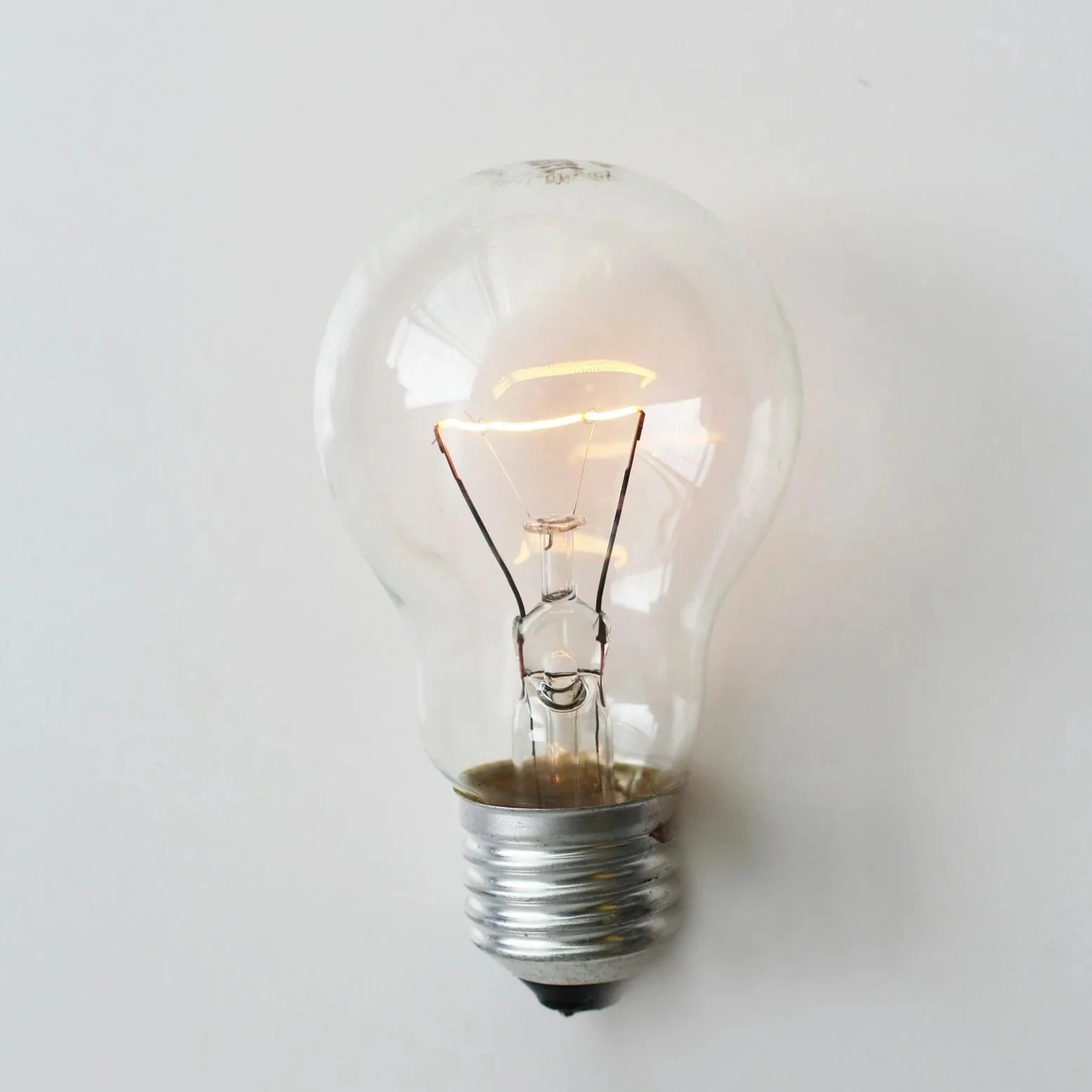 Close-up of an incandescent light bulb against a plain white background.