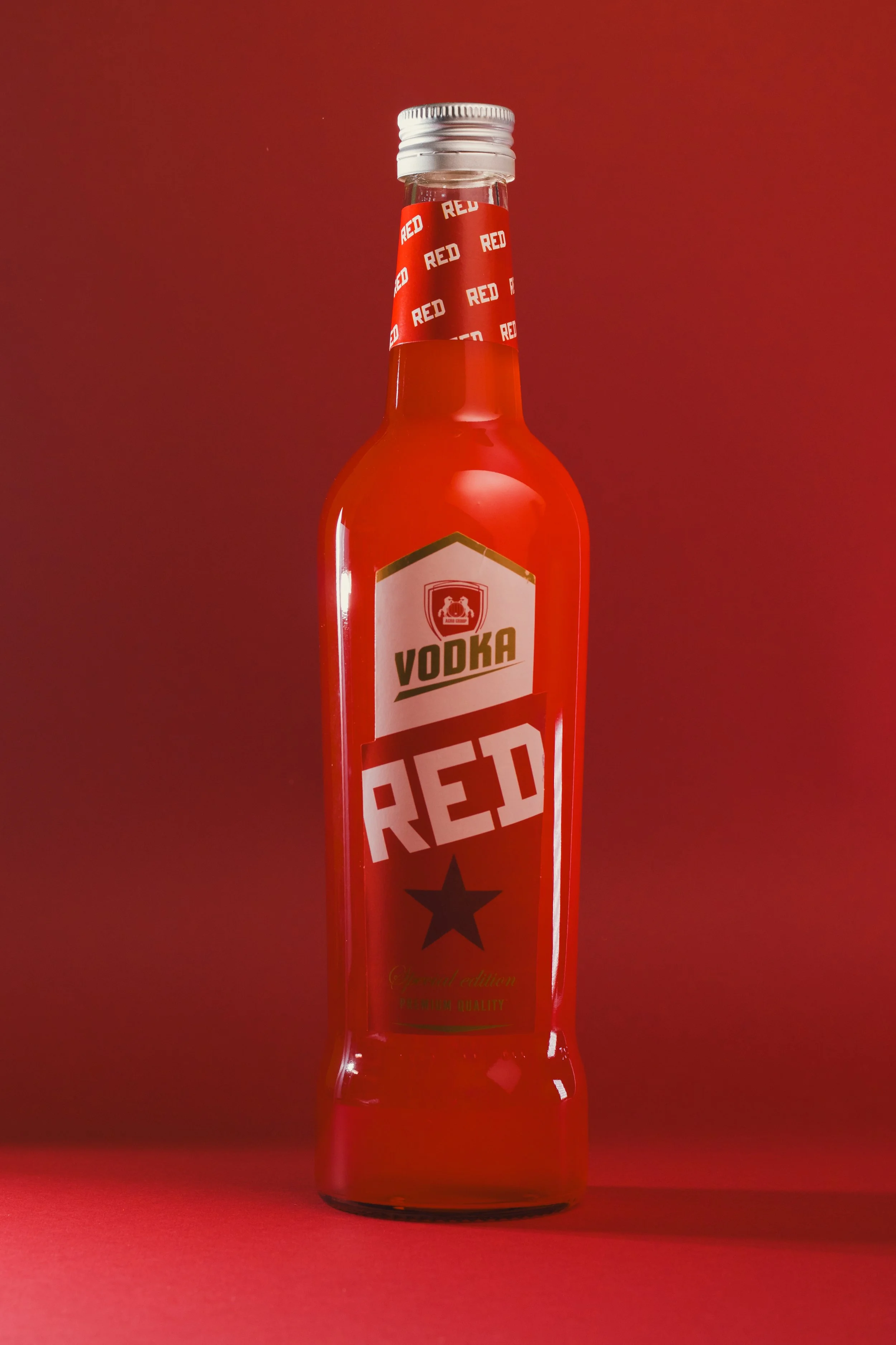 A clear glass bottle labeled 'VODKA RED' with a black star symbol on a red background.