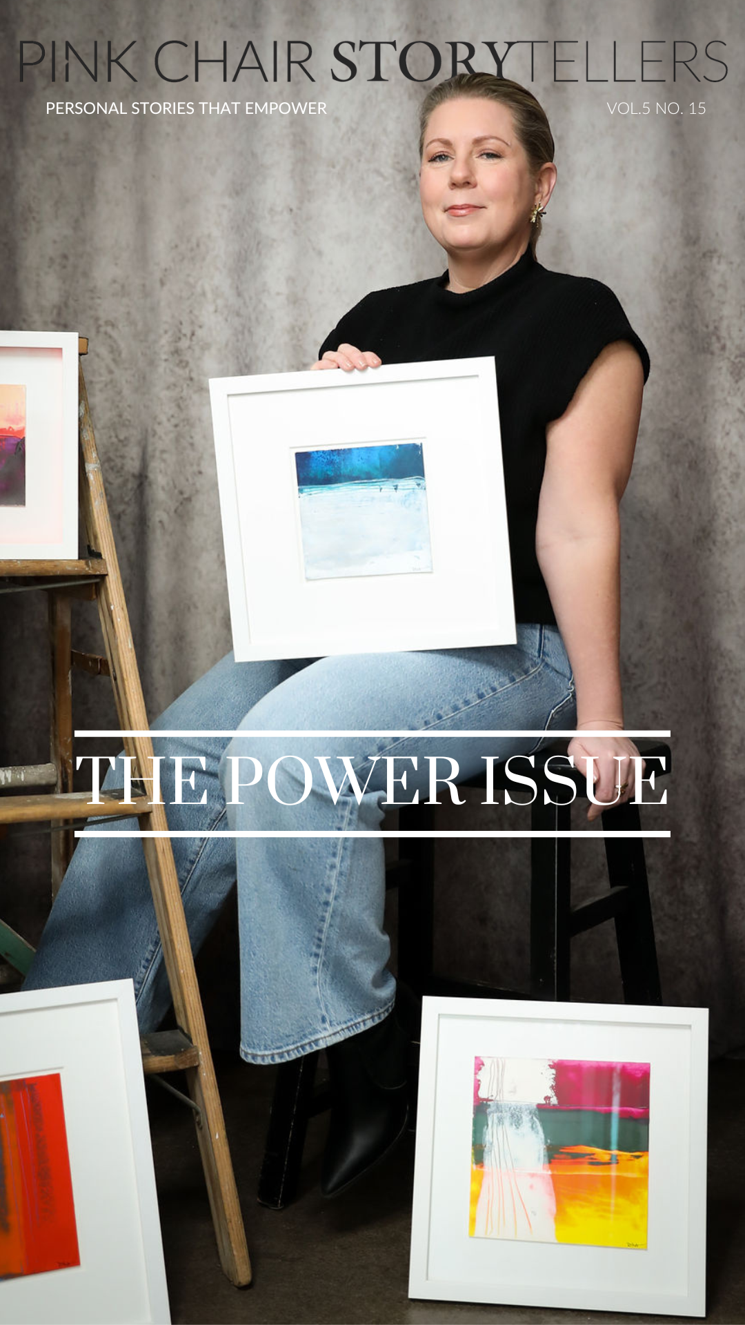 Artist Dina Brennan sits on a stool surrounded by her artwork