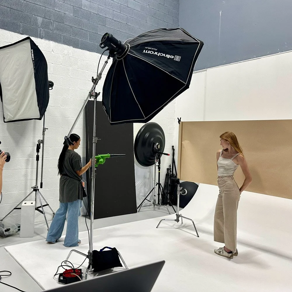 Flacon Media Solutions running a photoshoot in a studio with a woman model and a photographer.