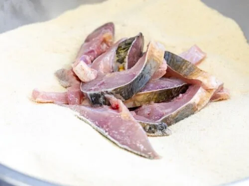 Filets de poisson avec peau, sur une surface blanche, prêts à être cuisinés.