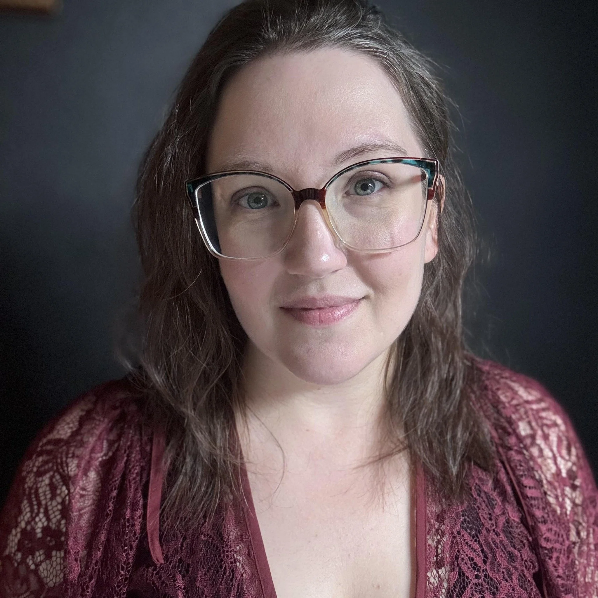 Haleigh King, a trauma-informed massage therapist in her 30s with glasses and hair down, in her calm Poway treatment room, offering gentle massage and nervous system–focused bodywork for clients with chronic pain, hypervigilance, and stress.