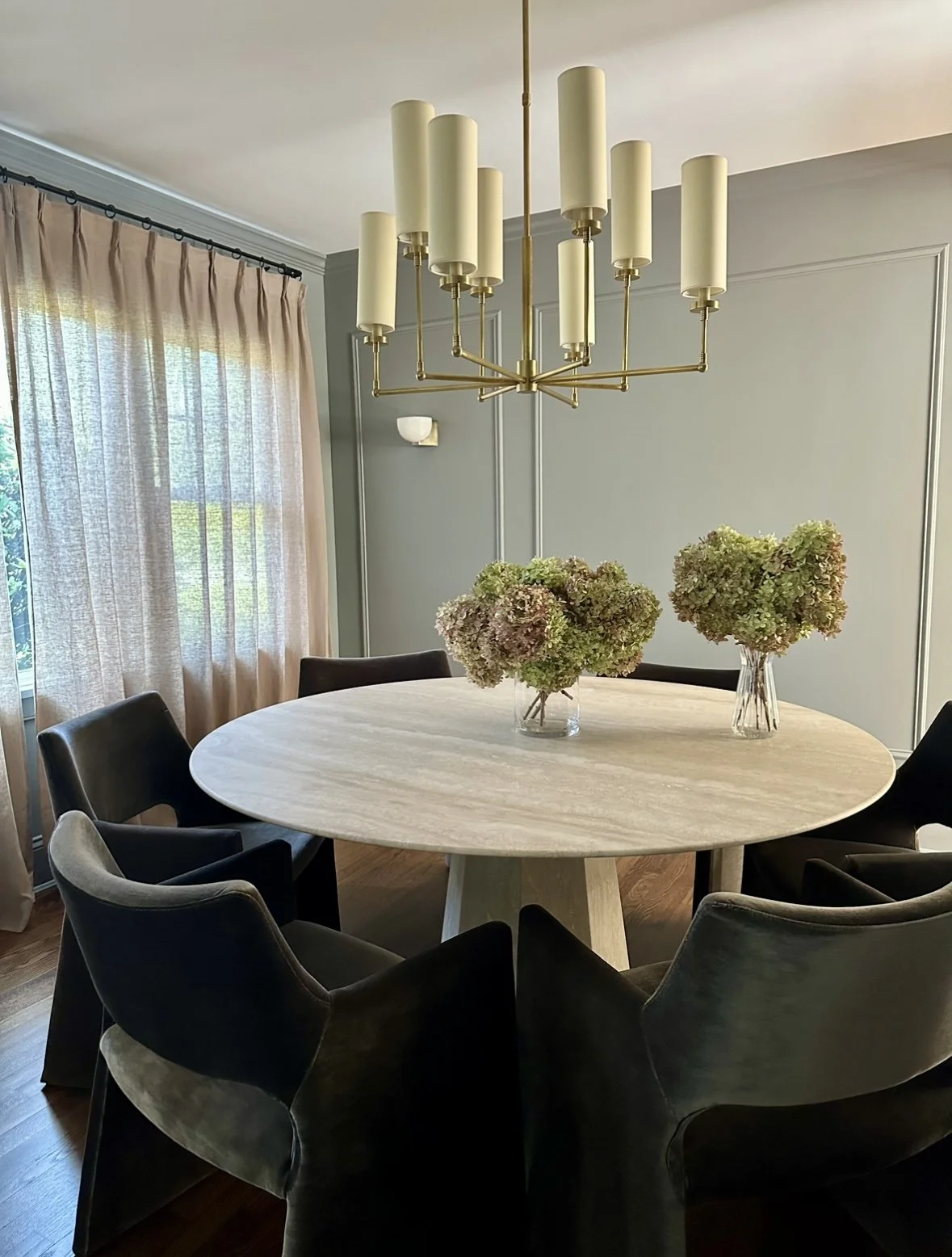 Modern dining room interior design with round marble table and brass chandelier