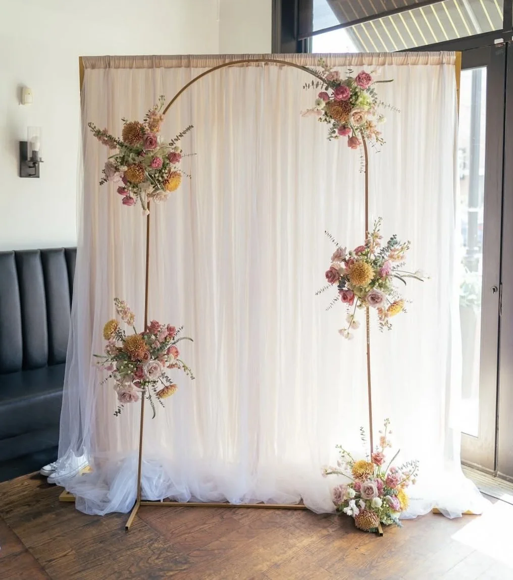 Wedding ceremony backdrop with white draping and hanging floral installations