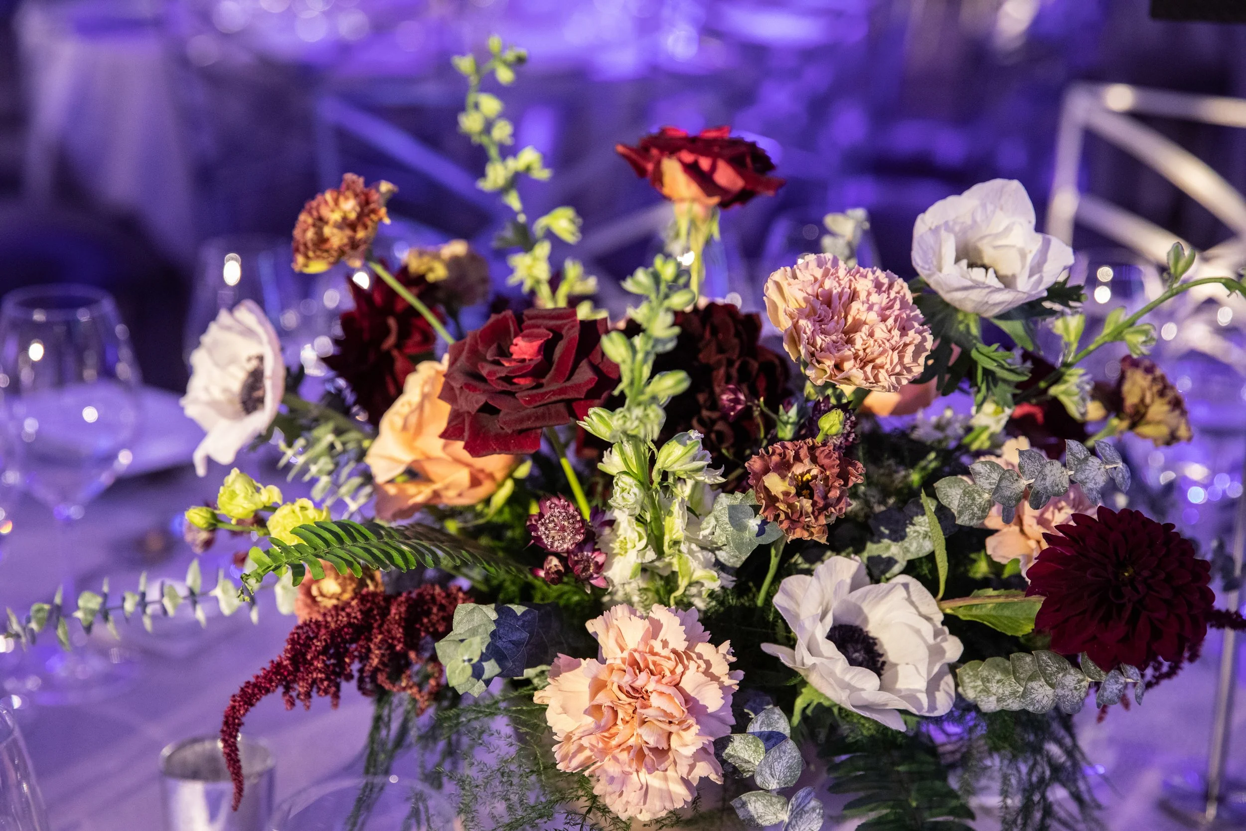 Moody purple and burgundy floral arrangement with anemones and textured blooms