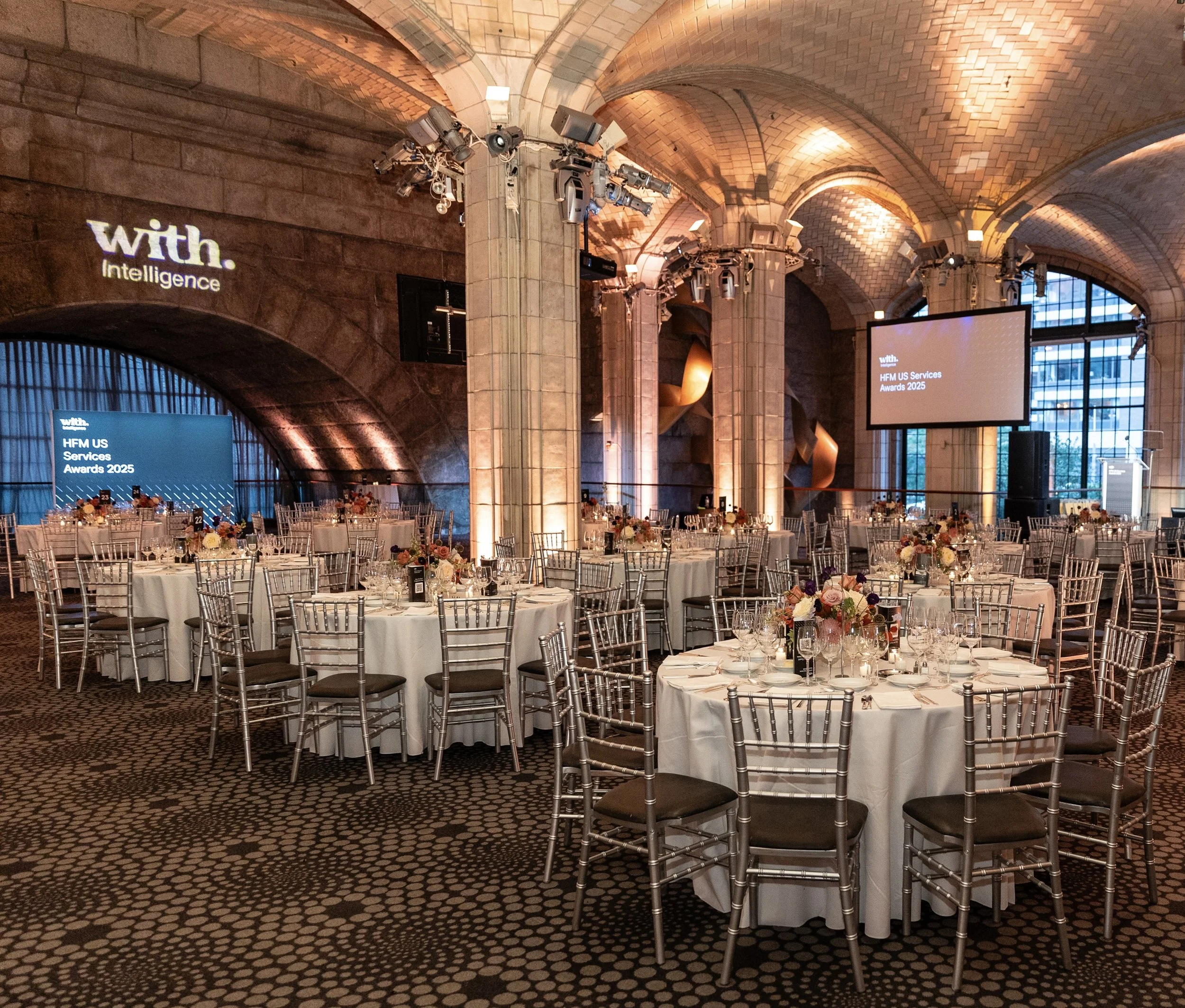 Grand ballroom wedding reception with crystal chandeliers and gold chairs