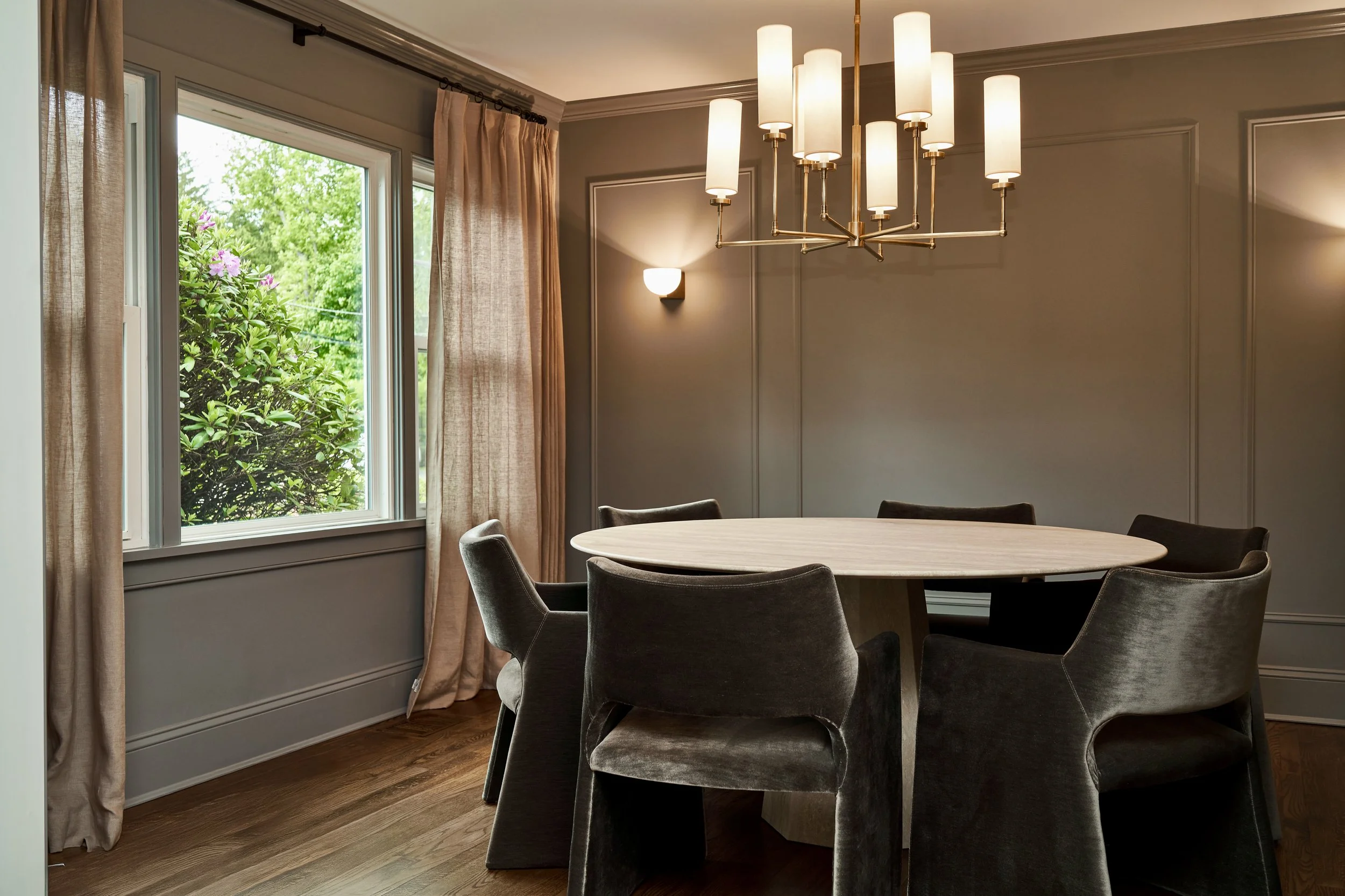 Warm contemporary dining room with modern lighting and neutral palette
