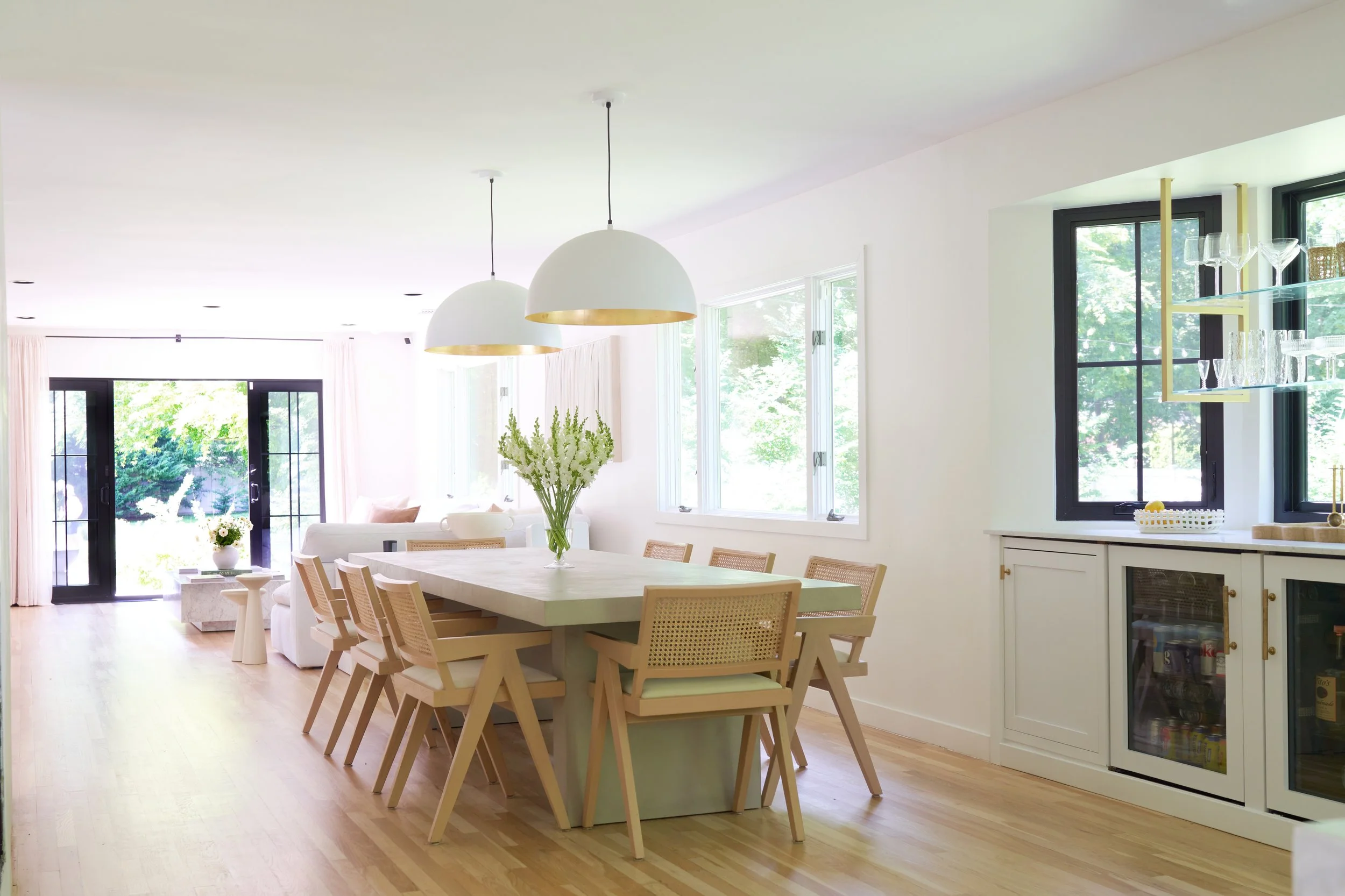 Bright modern dining room with wood table, sculptural chairs, and white pendant light