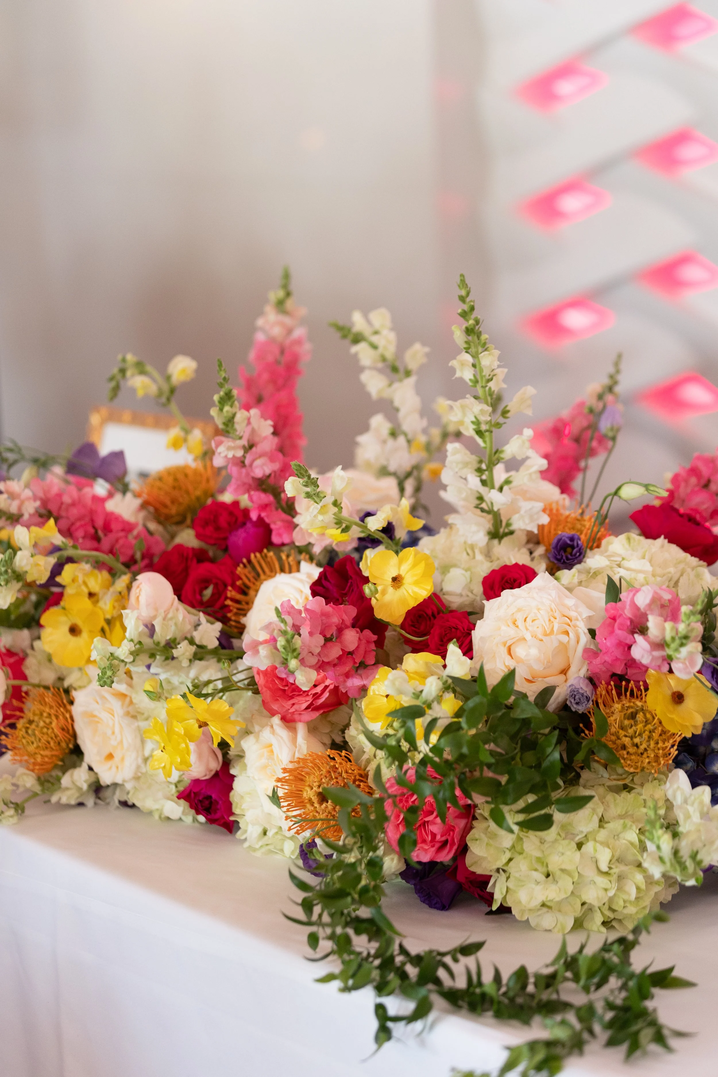 Bright summer centerpiece with hot pink, yellow, and coral flowers