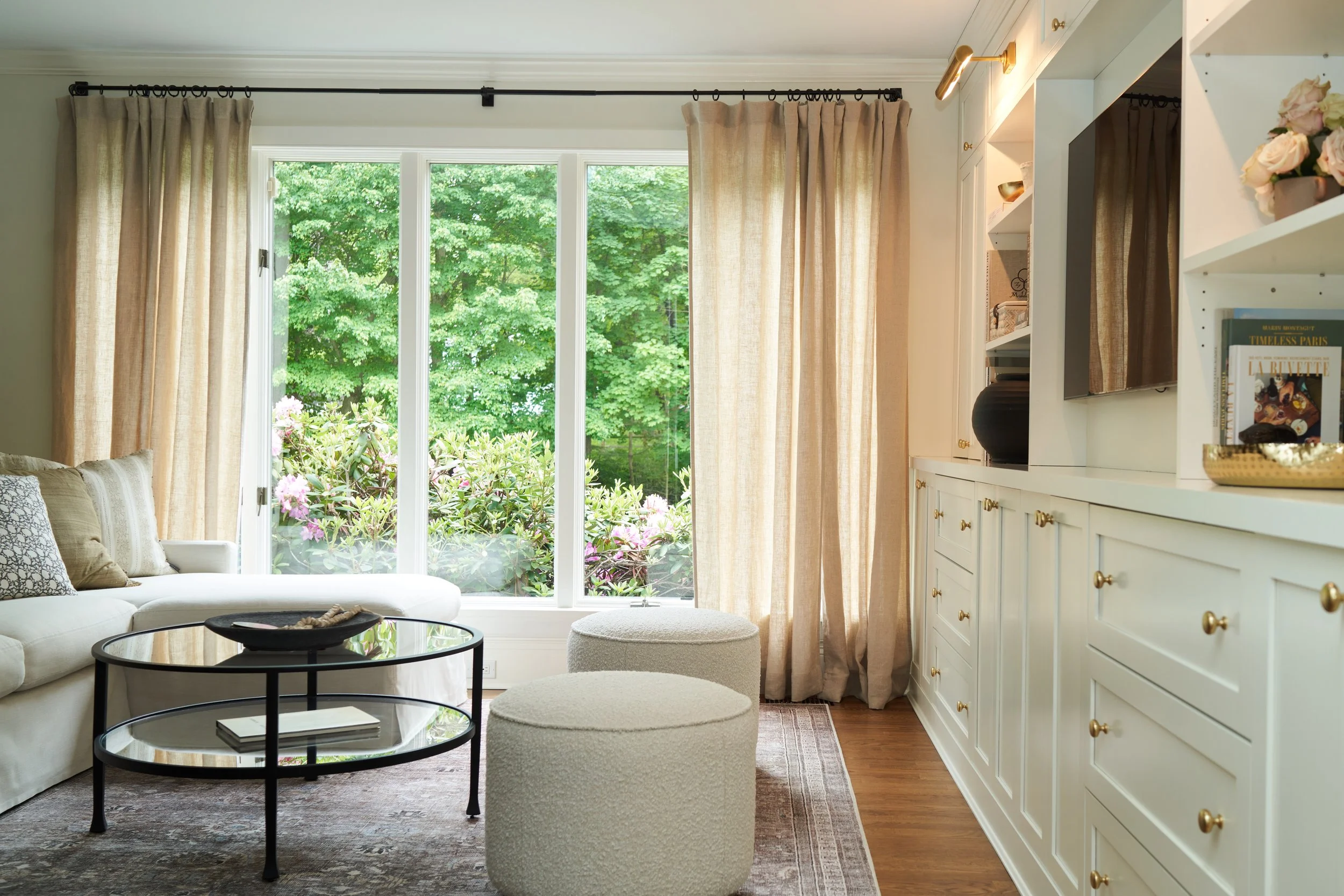 Traditional white cabinetry, boucle ottoman seating, and garden windows