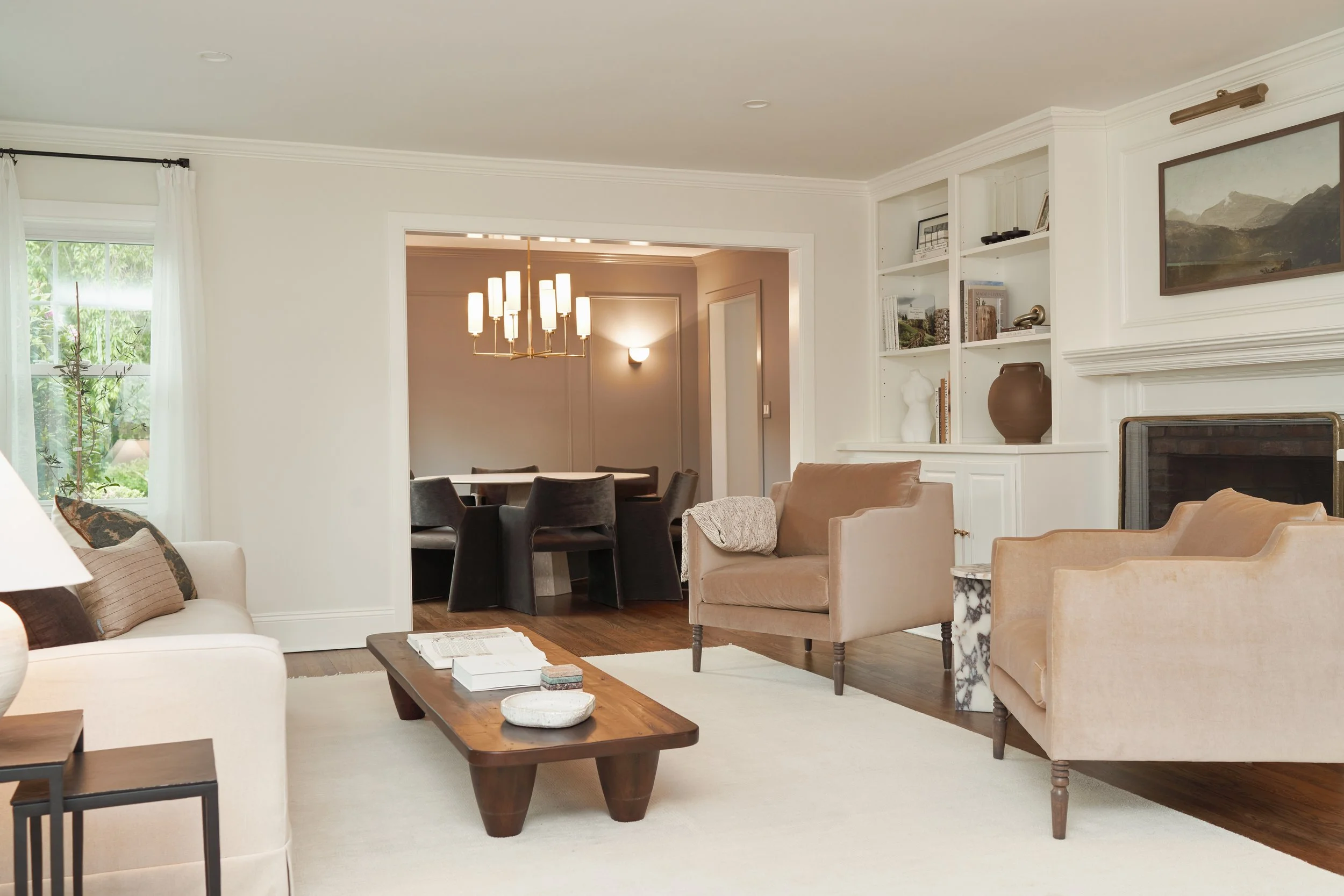 Cohesive open floor plan featuring white built-ins, modern lighting, and organic wood accents