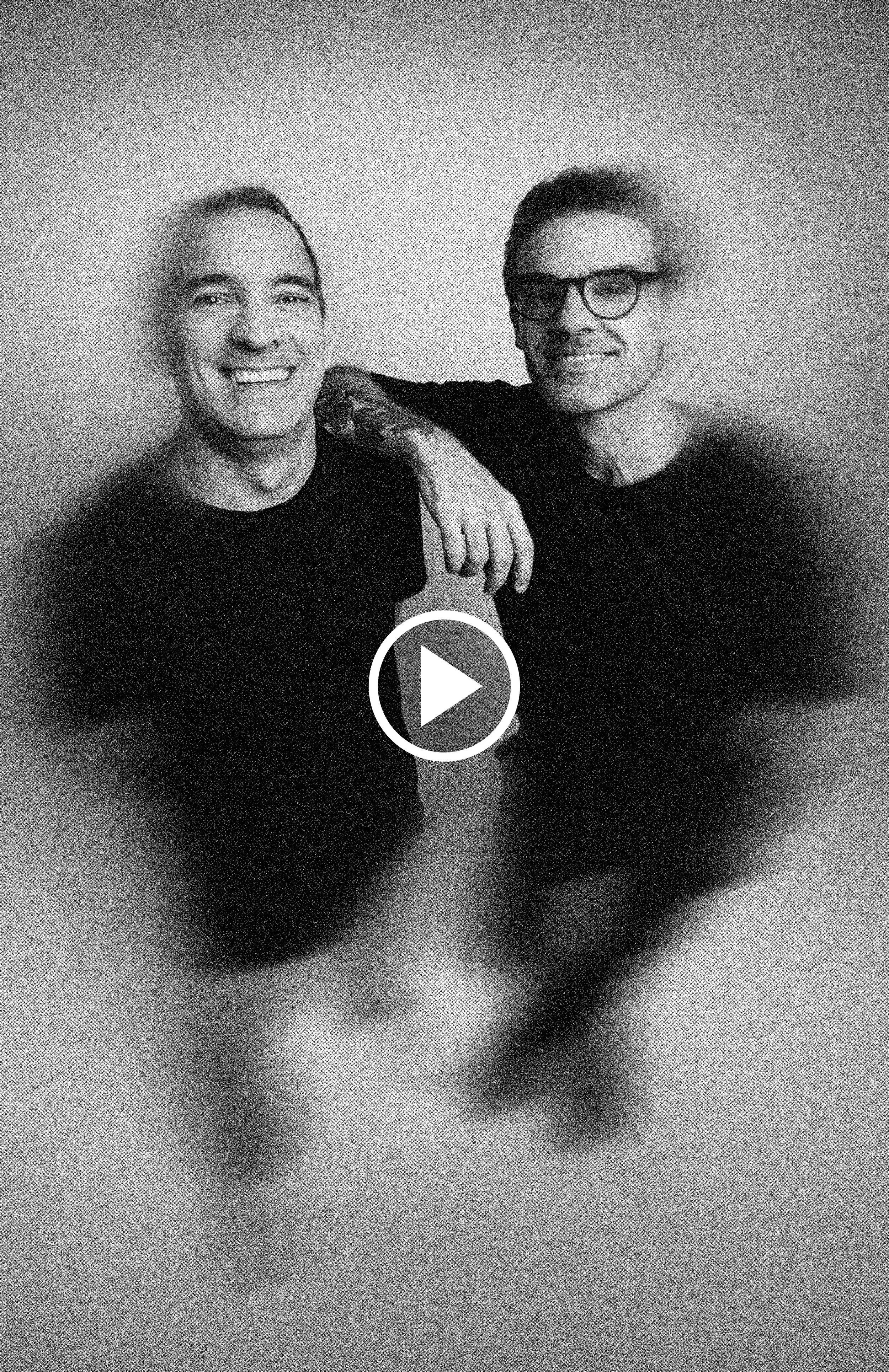 Dois homens jovens sorrindo, um com braço no ombro do outro, em foto preto e branco.