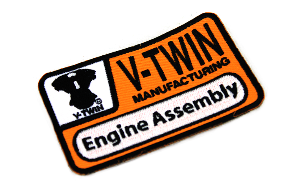 V-TWIN logo with a stylized black illustration of a V-twin engine on a white and orange background.