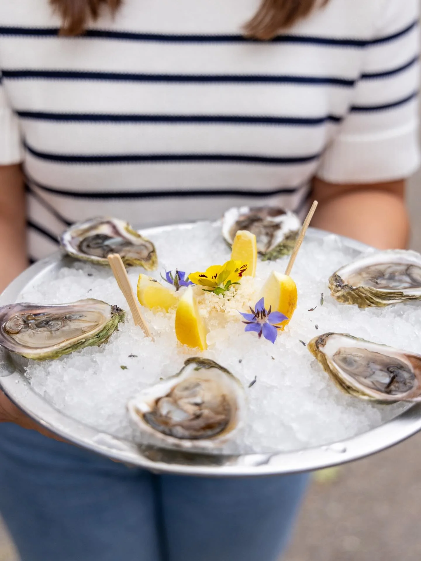 Savor the coast with our freshly shucked local oysters served on ice, garnished with lemon wedges and edible flowers. A taste of the sea, right where you are.

#oysterbar #thesaltwatersocialcb #discovercapebreton #destinationcapebreton #seafoodsydney