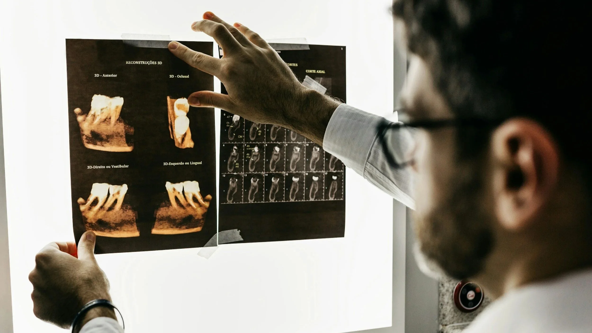 A medical professional examines ultrasound images on a lightbox, focusing on a 3D scan of a foot, with a display of multiple ultrasound scan slices on the right.