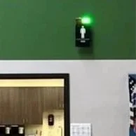 Restroom status indicator with a green light above a restroom door in a building