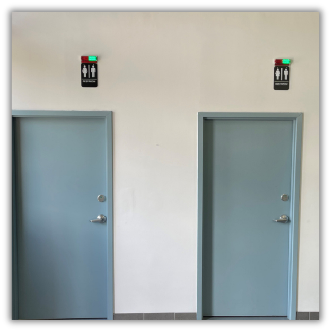 Restroom Occupancy Indicator Lights mounted above the door frames of two seperate restrooms
