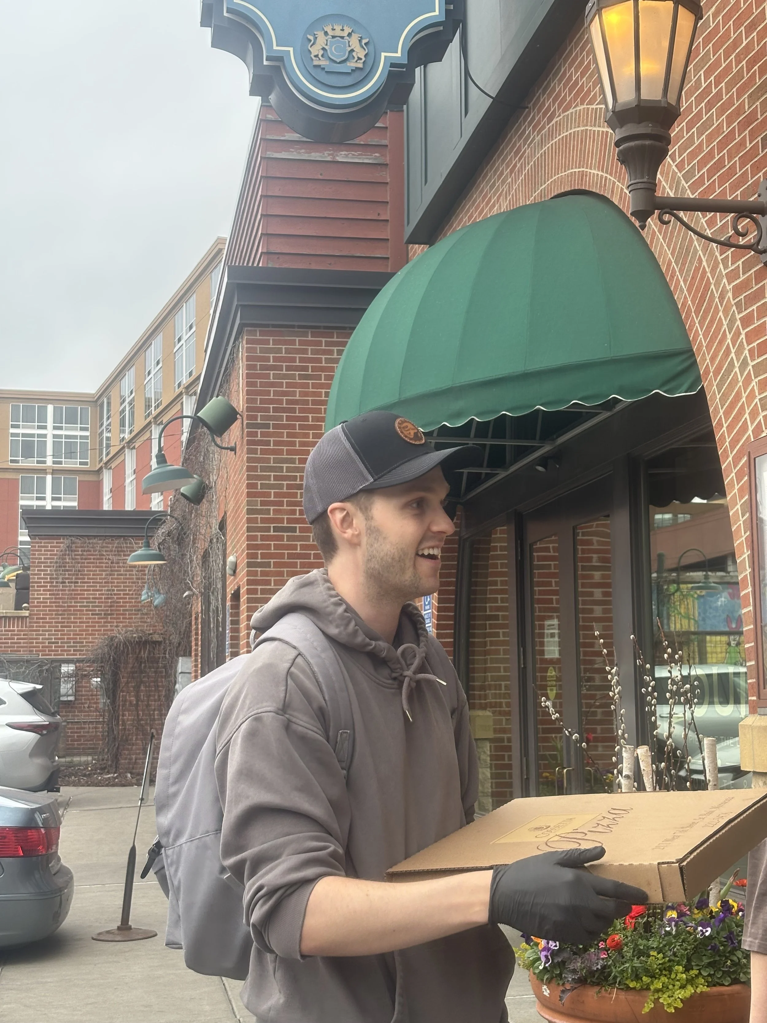 Man holding pizza box on St. Paul Signature Tour