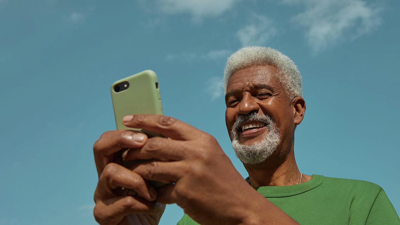 hombre trabajando con su celular mientras sonríe