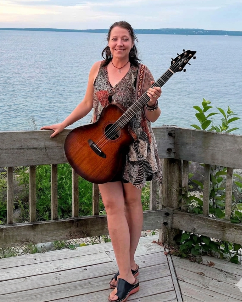 Amy Beach standing on a deck with Mackinac Island in the background