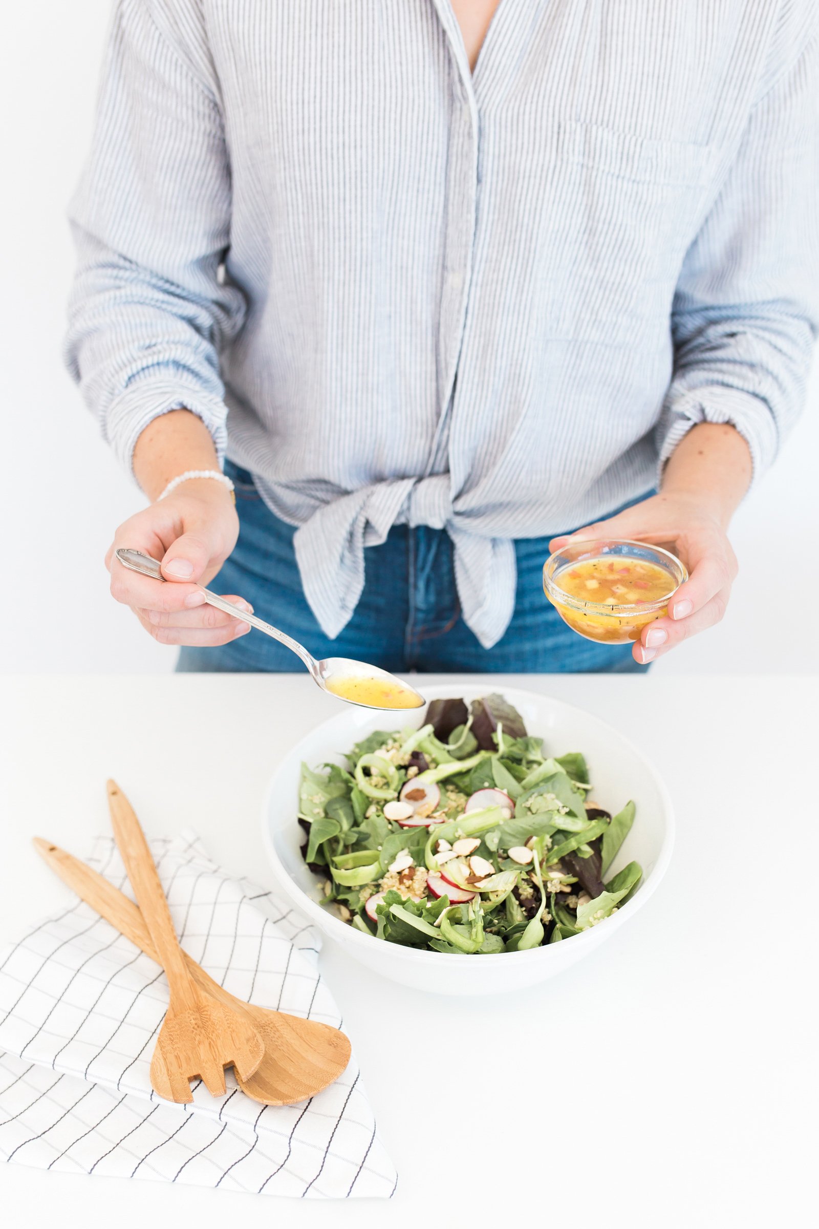 Hands preparing a fresh salad at home, reflecting gentle wellness habits and caring for the body with kindness.