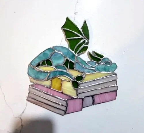 Stain glass dragon on books. new to stain glass.  stain glass amateur sun catcher.