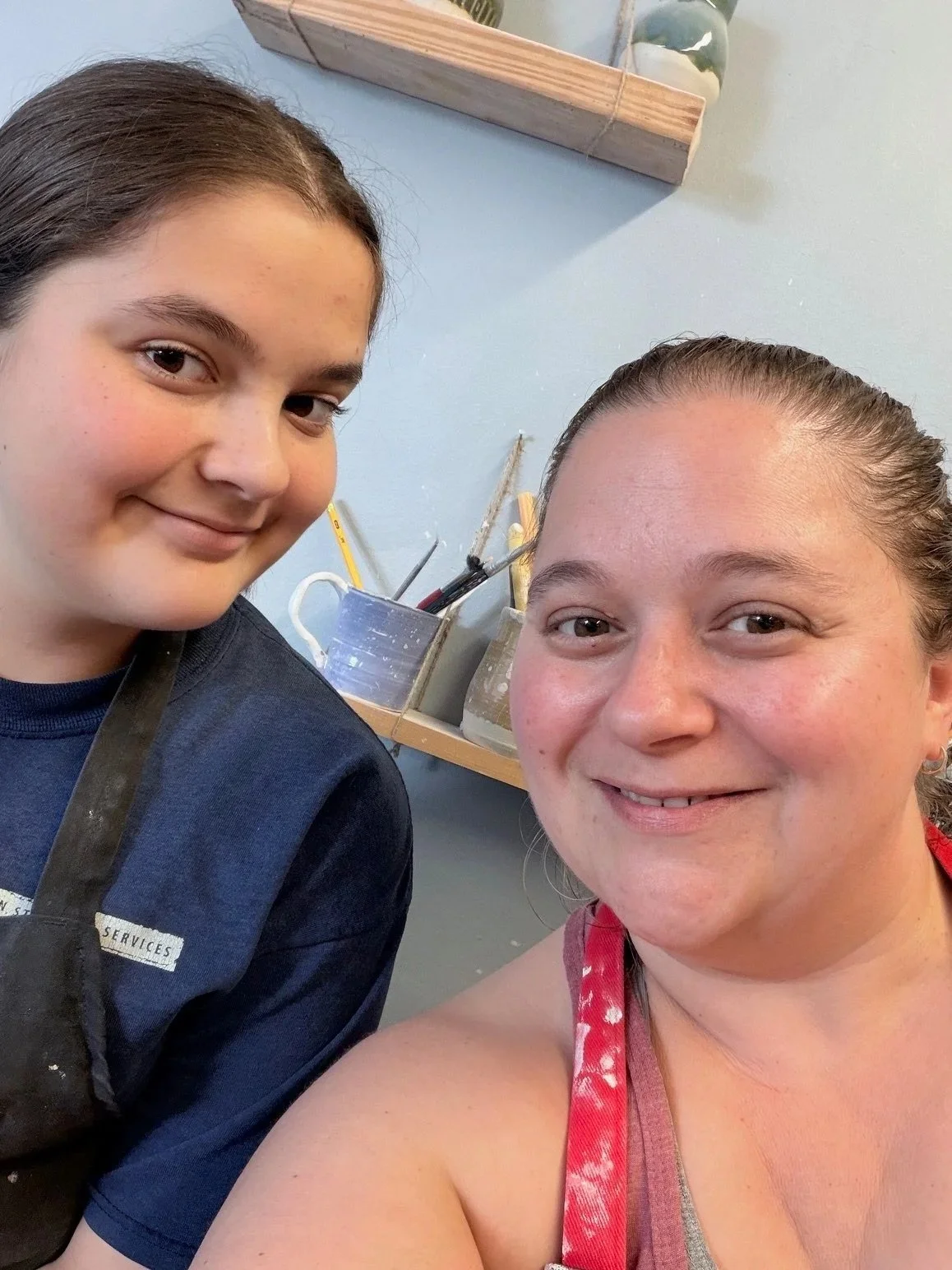 Art is more fun with friends and family, Community art studio. two smiling women taking a selfie in a craft or pottery studio, with art supplies in the background.