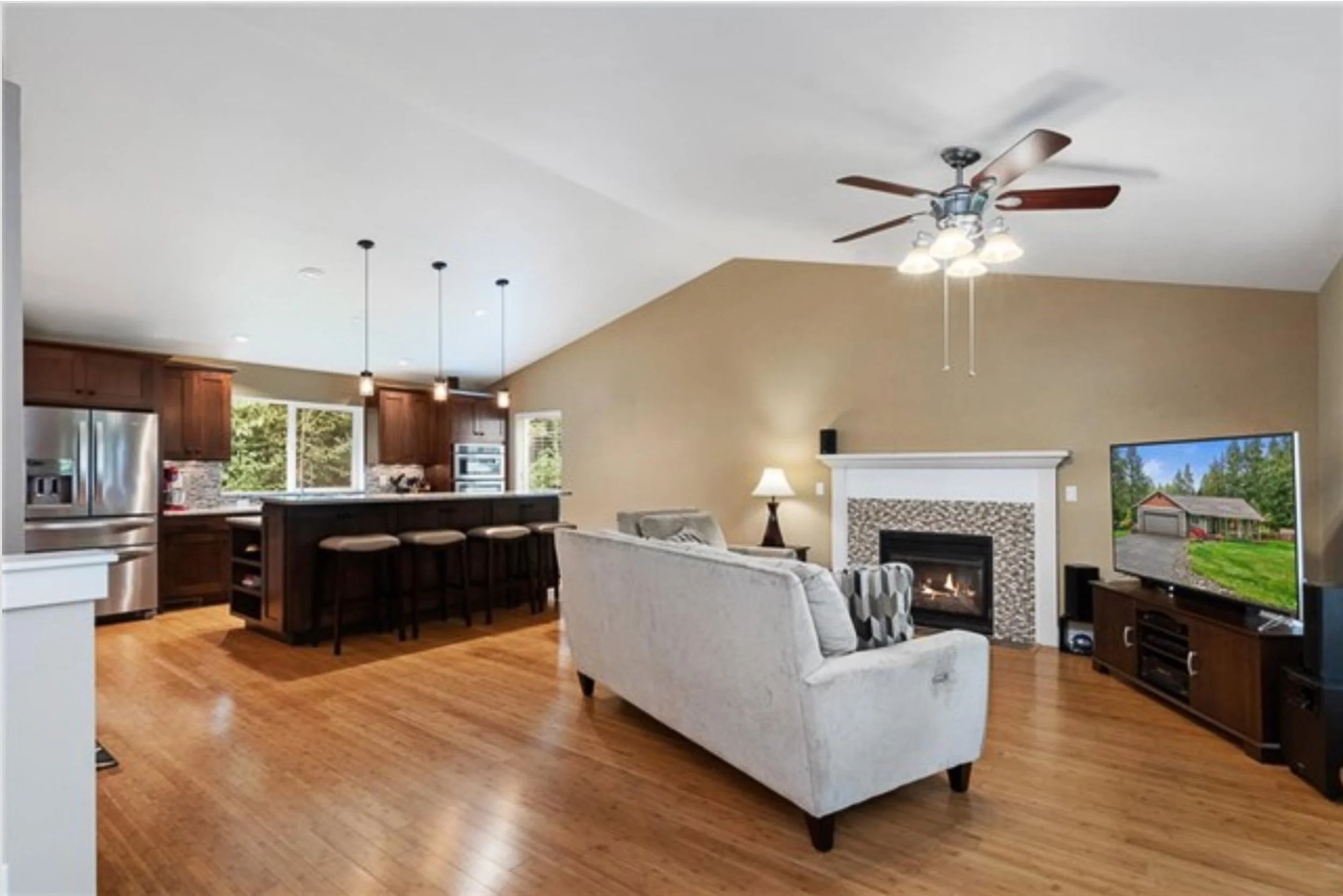 The unified family and kitchen space showcasing the warm palette of rich wood and natural light. A visionary design-build project in Kitsap County built for connection and modern living.