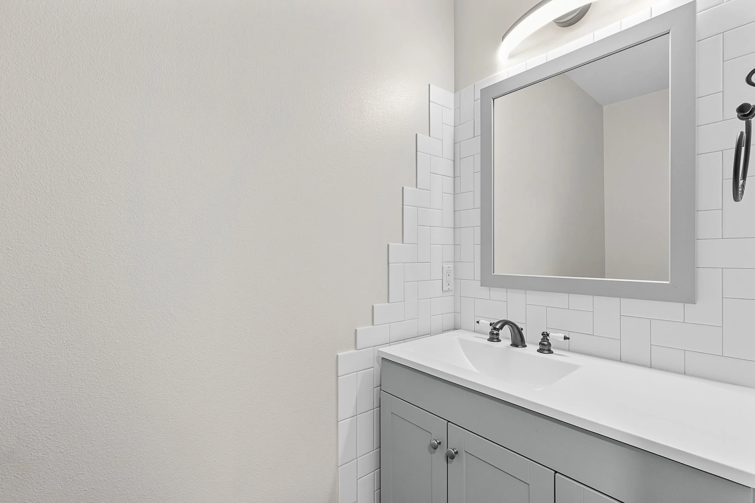 The completed Project Trussel powder bath in Kitsap County. A modern, intentional transformation featuring a clean, fresh palette, textured backsplash, and custom cabinetry for modern living.