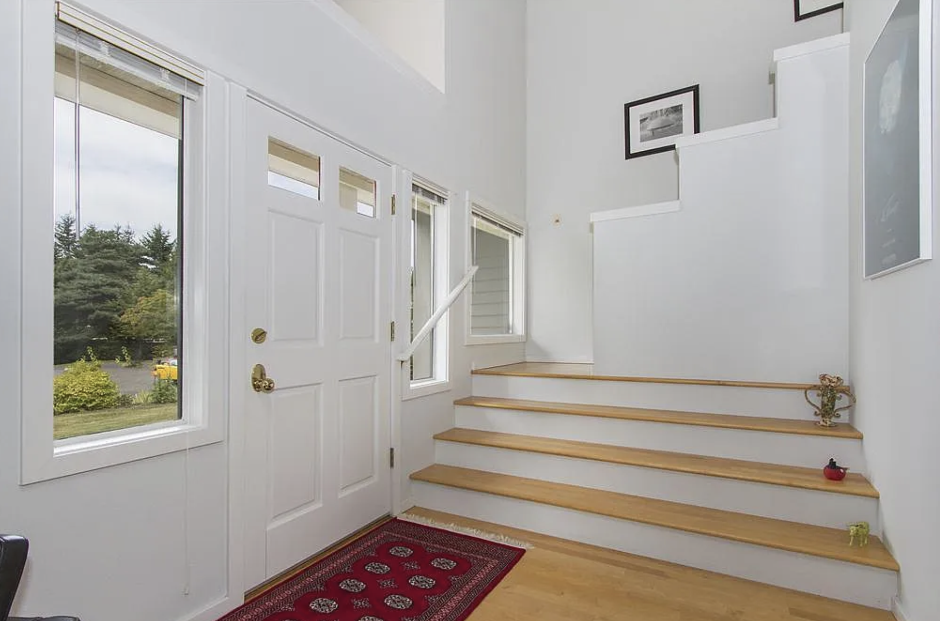 Original staircase layout before reclaiming square footage for an integrated drop zone. A Kitsap County home renovation showcasing the transition from underused space to intentional, functional storage.