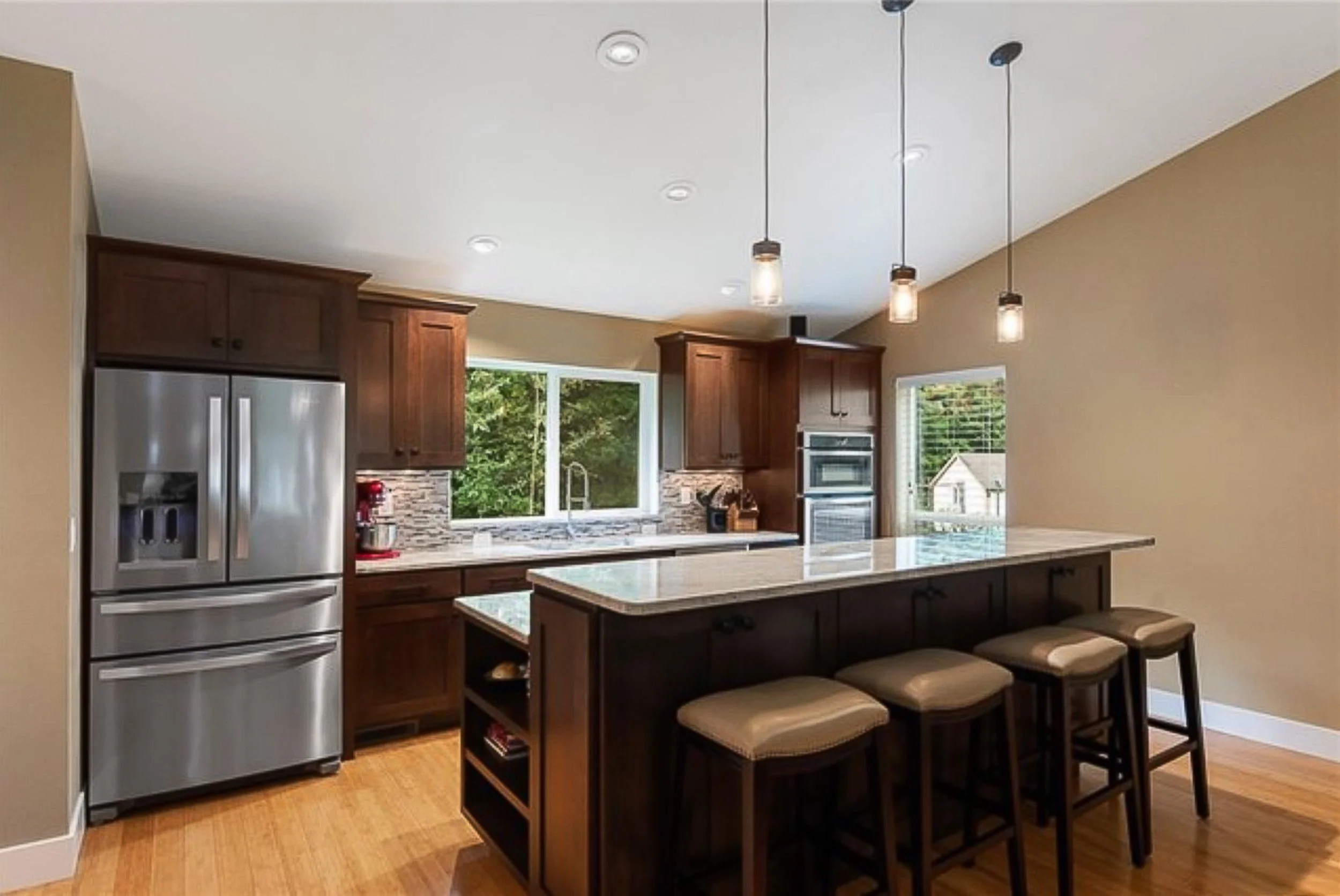 Completed kitchen relocation in Kitsap County featuring rich wood cabinetry and hardwood floors. An intentional, warm modern design highlighting high-end craftsmanship and natural textures.
