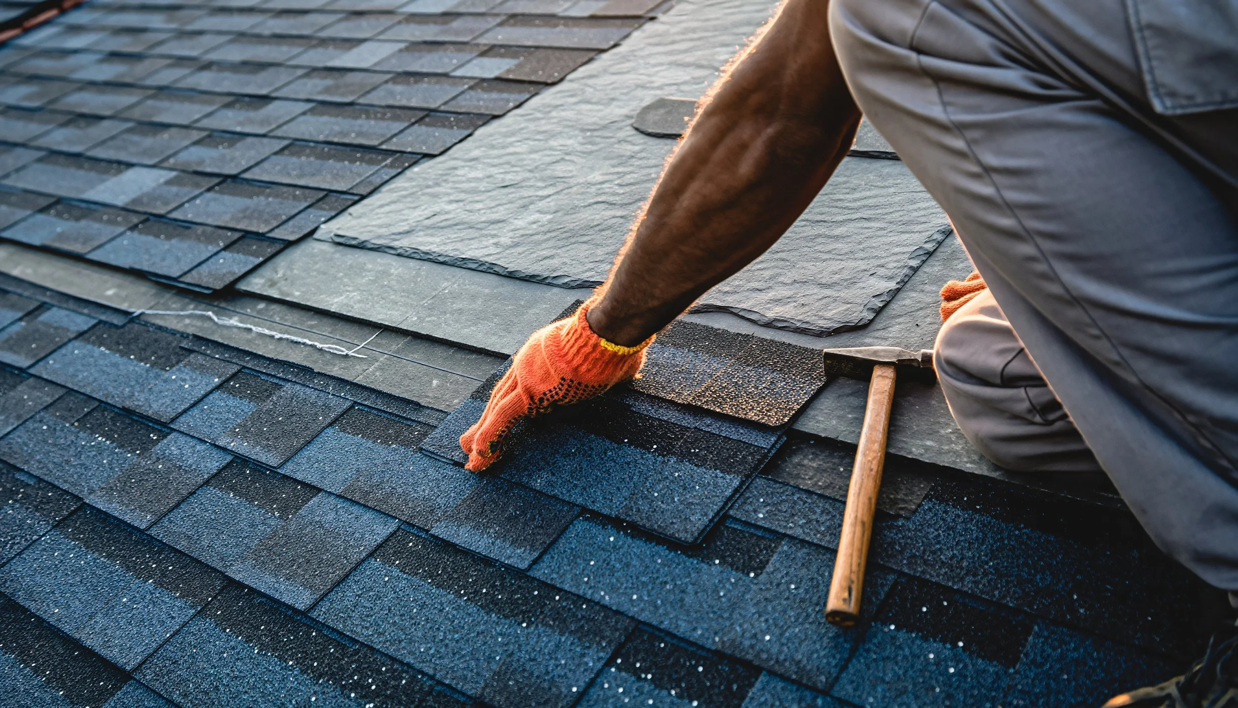 vecteezy_close-up-of-a-roofer-installing-dark-blue-asphalt-shingles_74237213.jpg