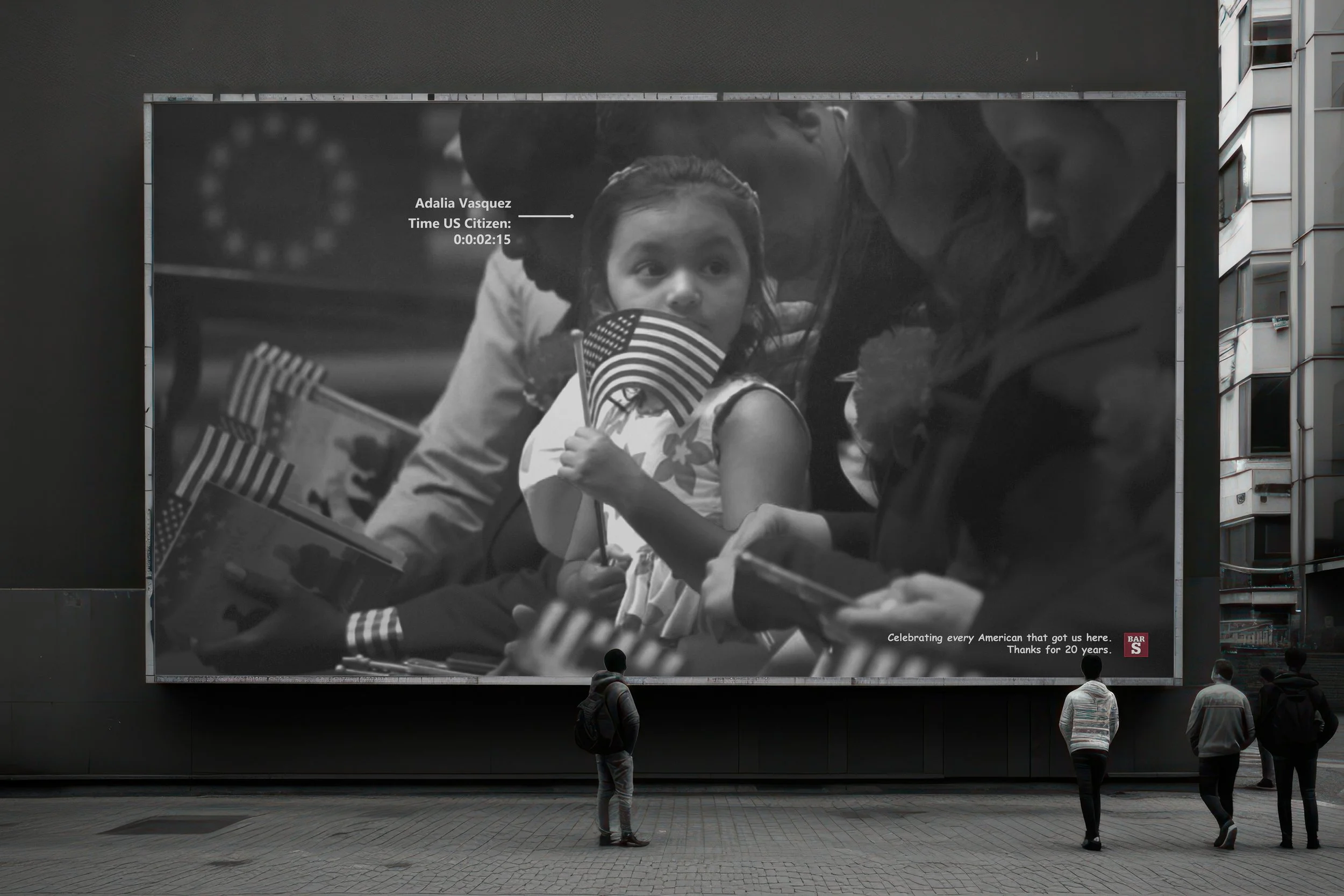 A black-and-white advertisement on a large billboard showing a young girl holding a small American flag, sitting among adults. Several pedestrians stand in front of the billboard, observing the display on an urban street.