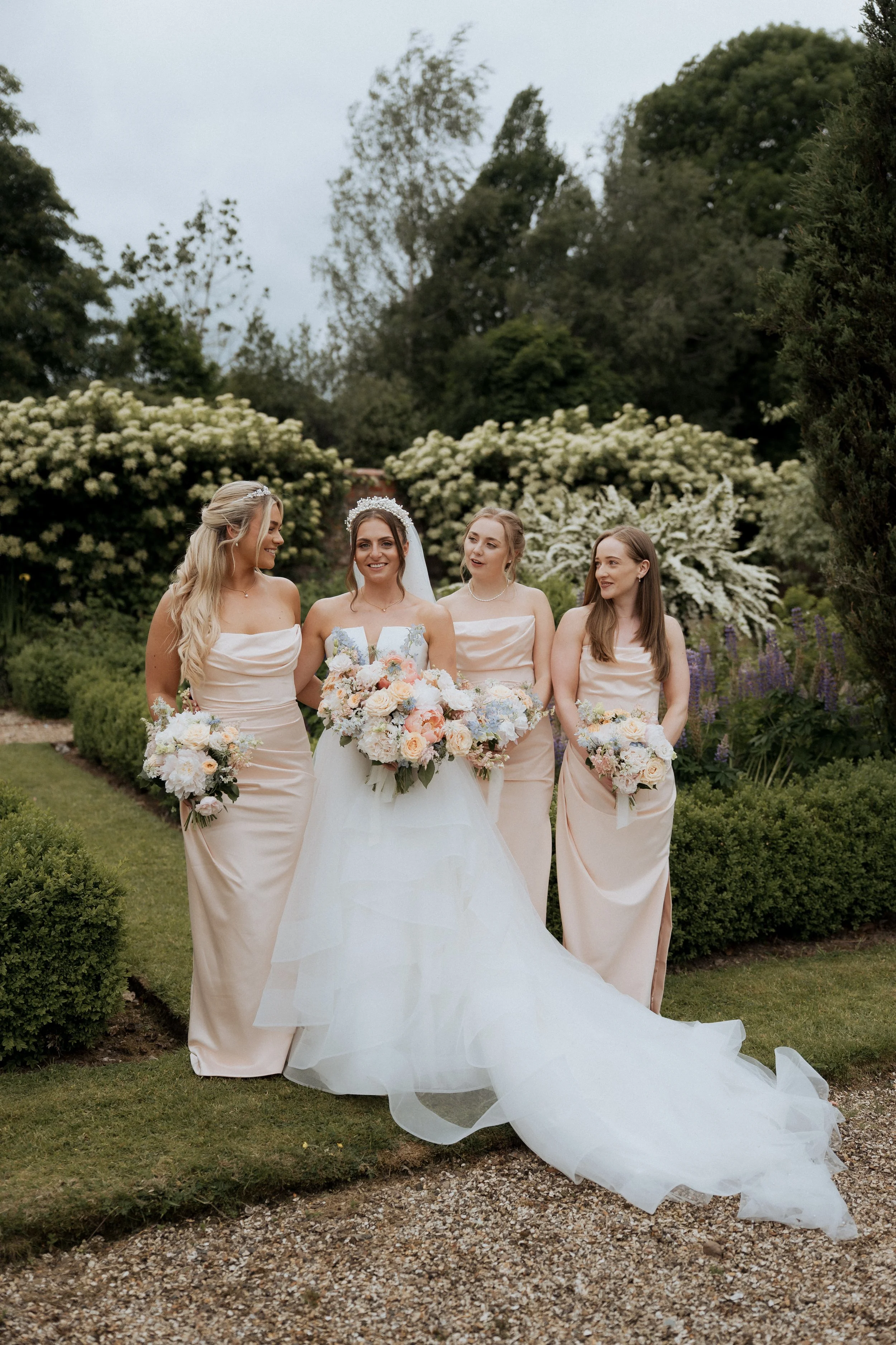 Laurie’s customers, Mariana and Carmen holding hands on a green lawn on their wedding day.