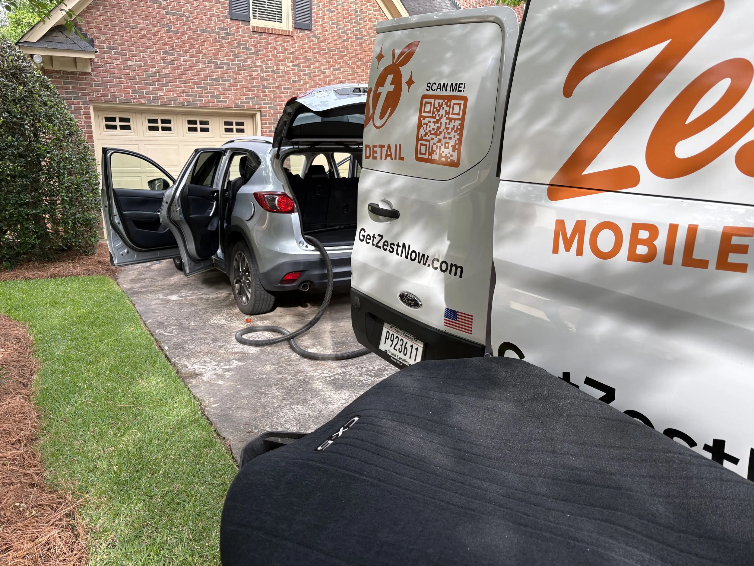 Our fully equipped mobile detailing team servicing a Mazda CX-9 at a customer's home in Columbia, SC. Zest Mobile Detail brings professional interior and exterior car detailing directly to your driveway, workplace, or garage throughout Columbia, Lexi