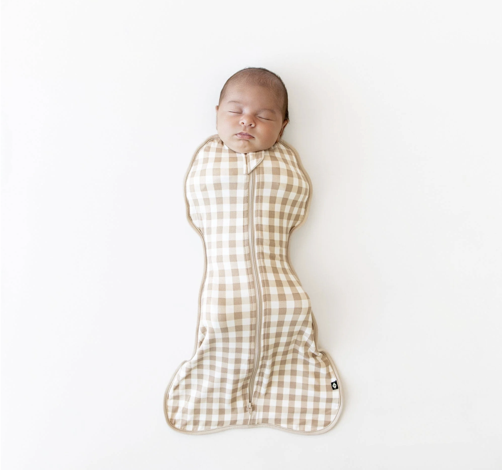 A sleeping baby with a checkered blanket resembling a koala bear on a white background.