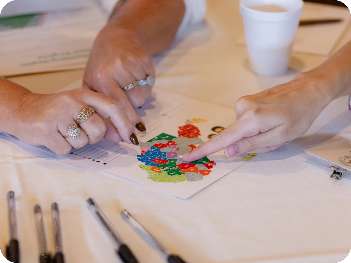 Three people are pointing to a map of West Virginia.