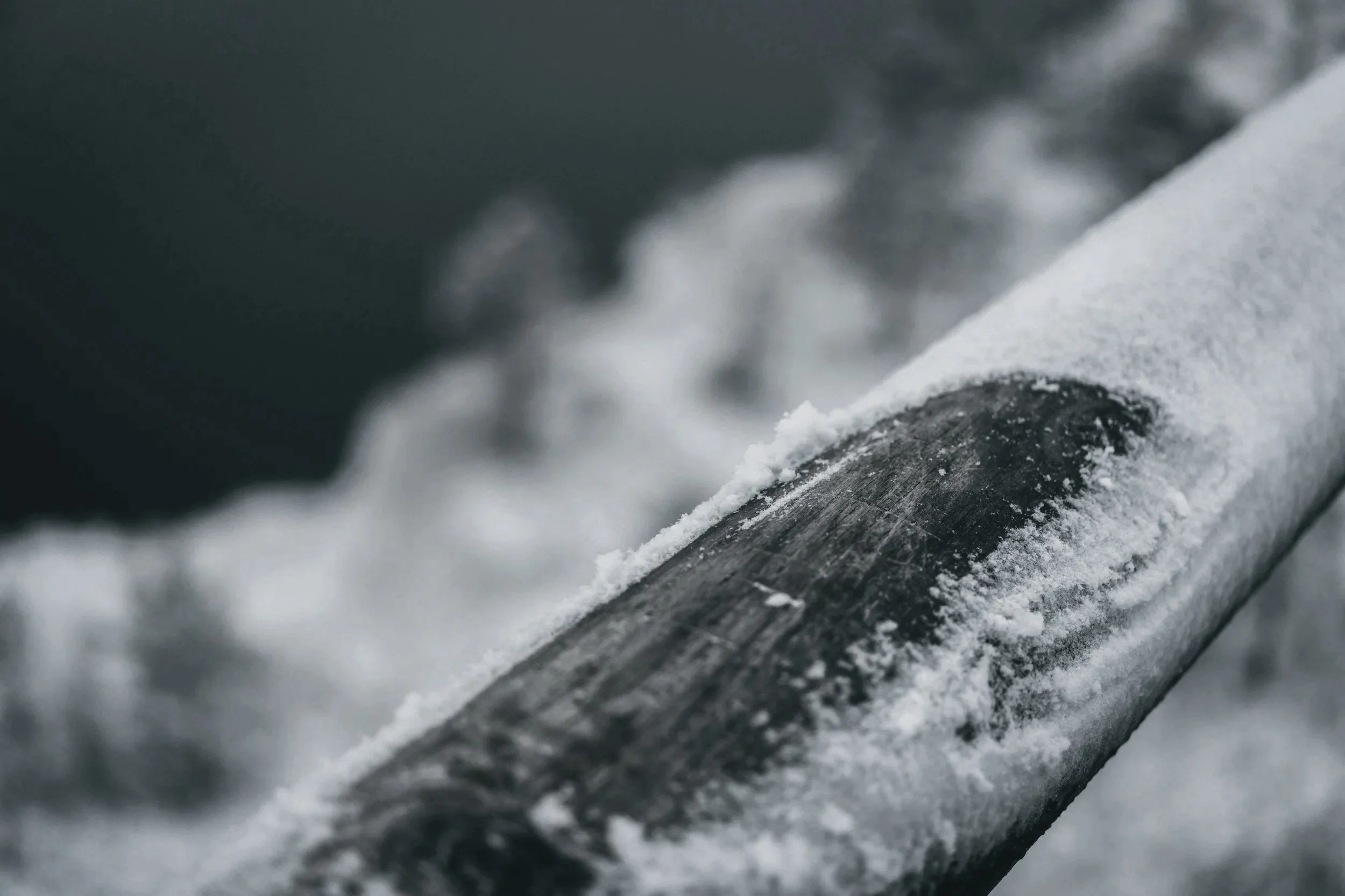 Close-up of a snow-covered hockey stick on ice
