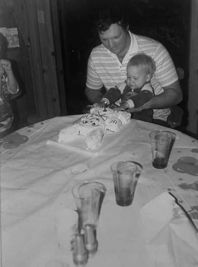 Father and son eating a cake celebrating a birthday