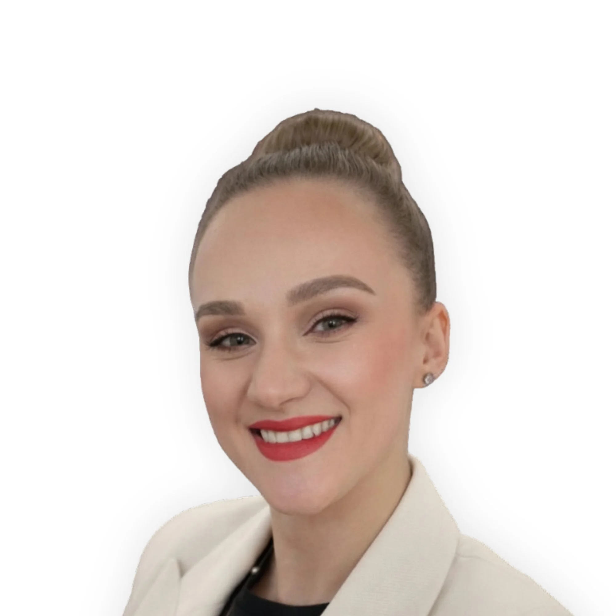 Professional woman with blonde hair styled in a bun, wearing makeup, red lipstick, and a white blazer, smiling against a white background.