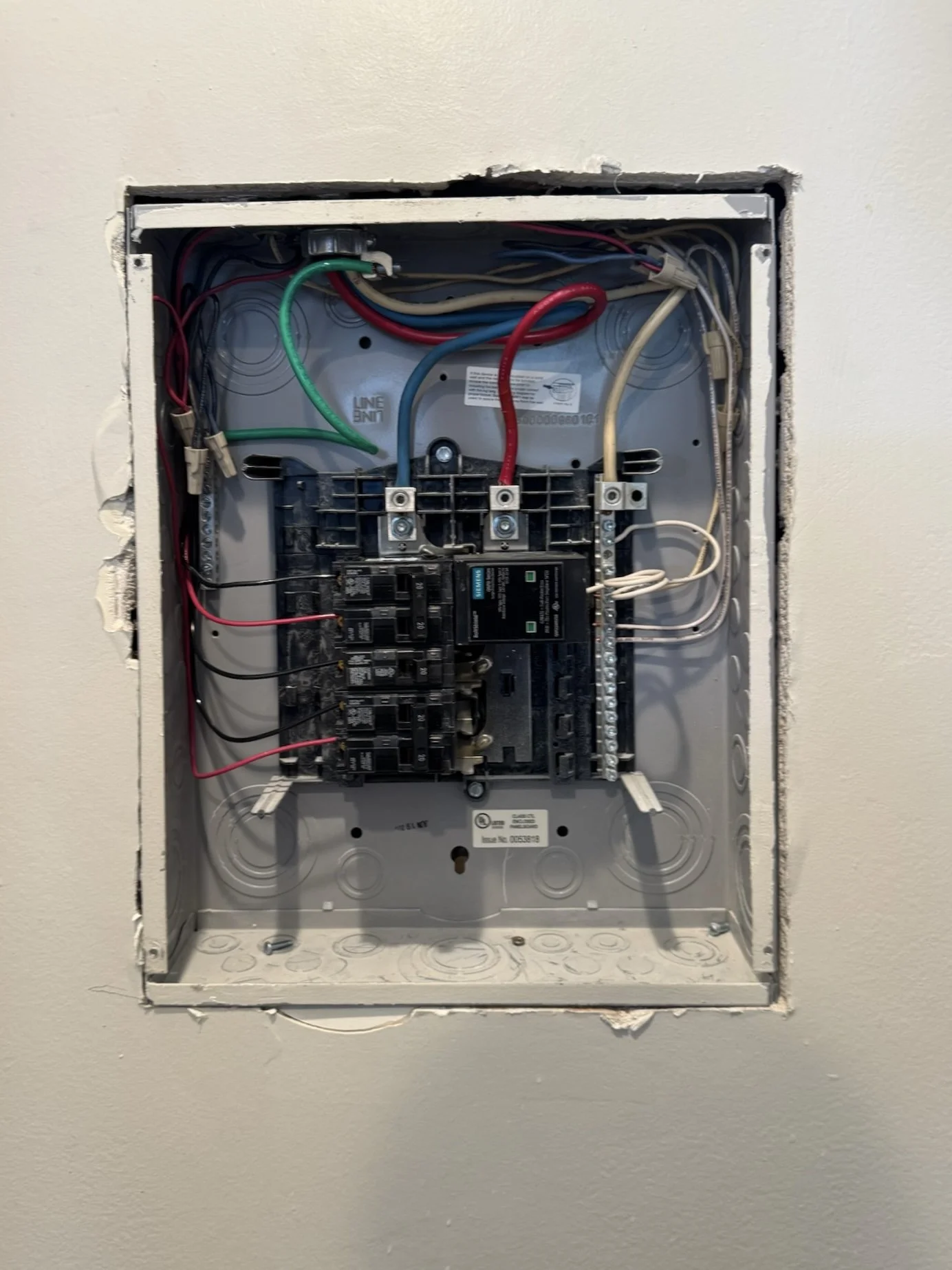 Open electrical breaker box with wires inside.