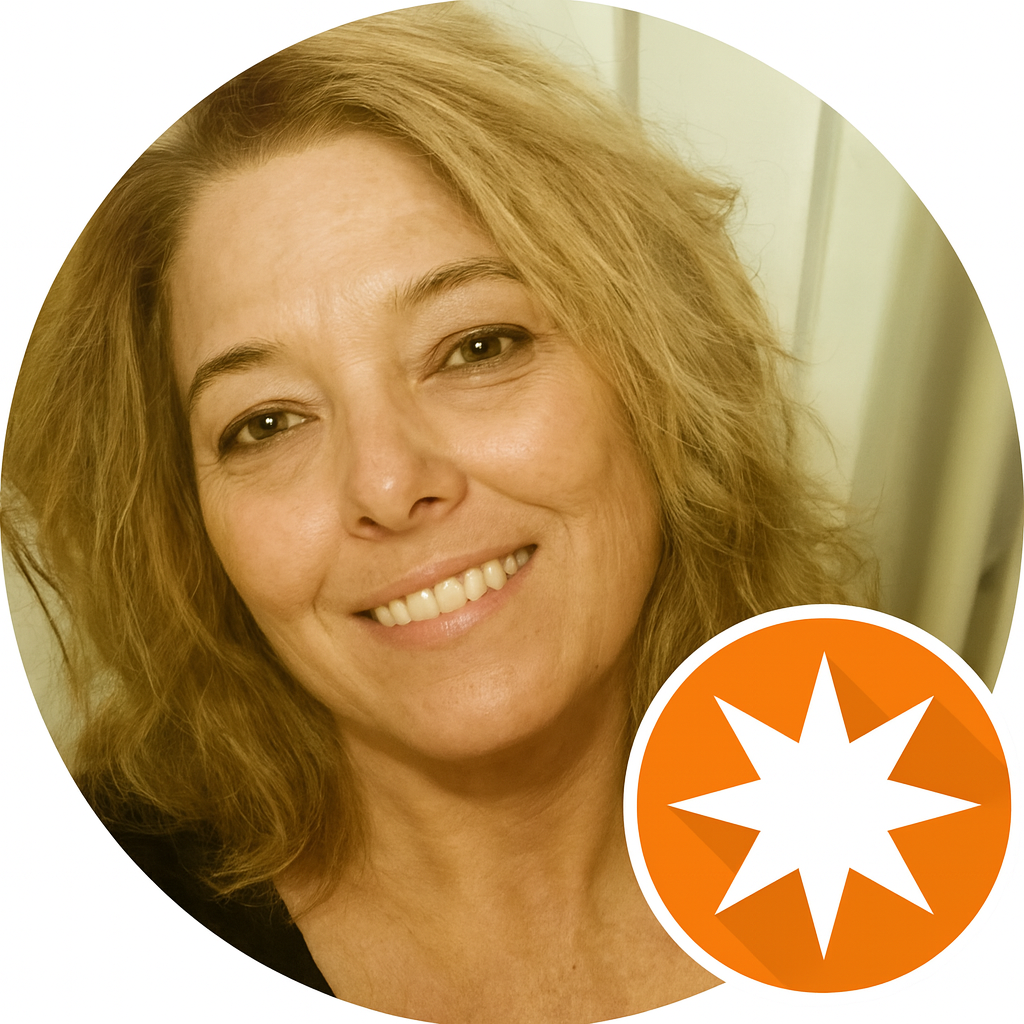 Close-up of a woman with curly blonde hair smiling at the camera.