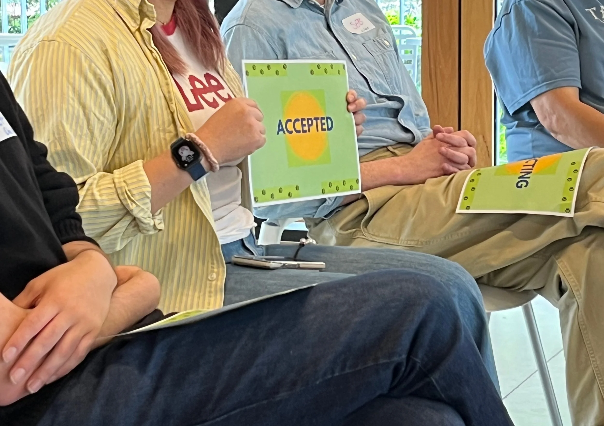 A person holding a card that says 'accepted'