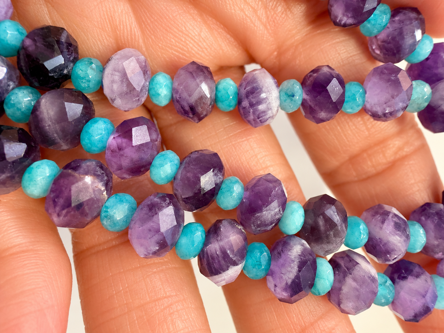 Faceted Amethyst and Turquoise Beads in Hand.png