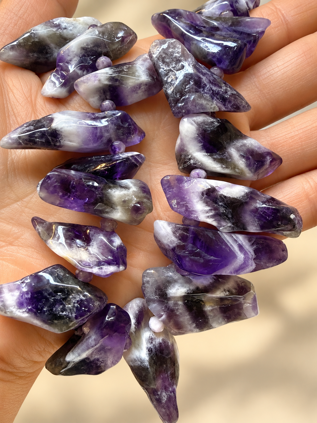 Polished Amethyst Chip Strand in Hand.png