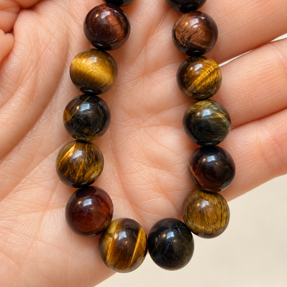 Polished+Tiger%E2%80%99s-Eye+Bead+Strand+in+Hand.png