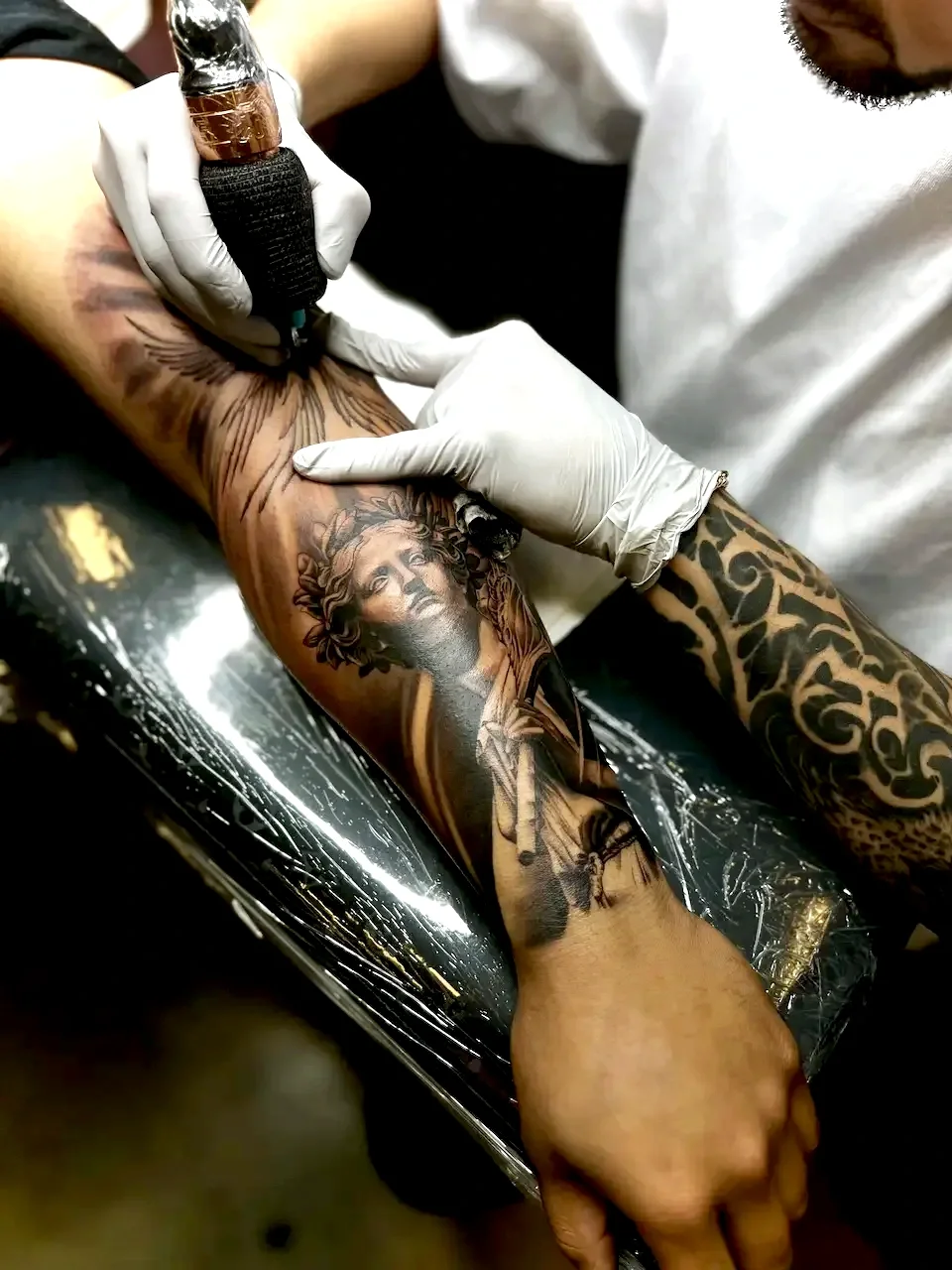 Johny Vasquez tattooing a detailed black and gray full sleeve tatttoo with intricate shading and line work in Austin, TX