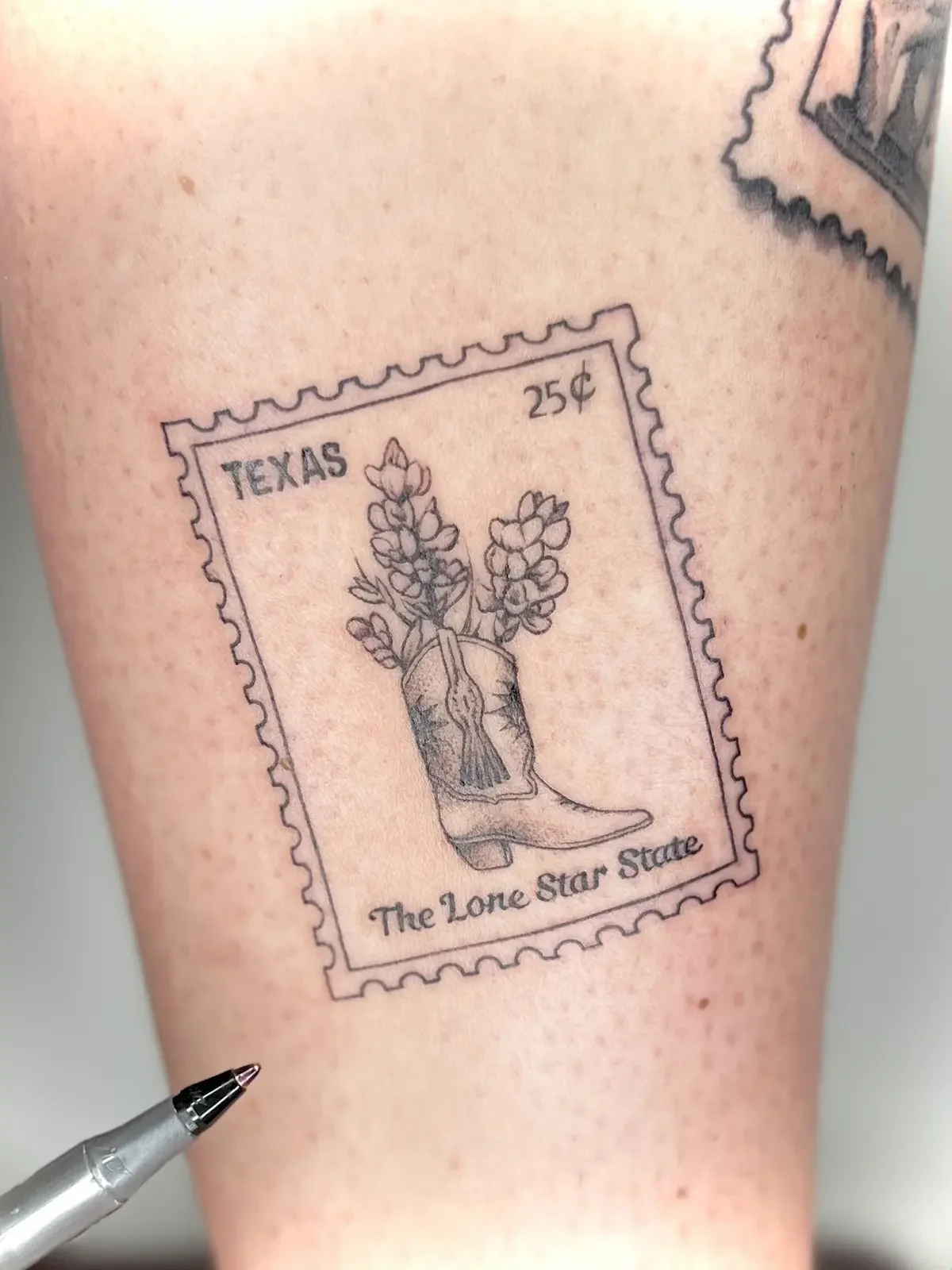 Custom Texas vintage postage stamp tattoo with cowboy boot by Austin tattoo artist Johny Vasquez - Mommasboy Tattoo