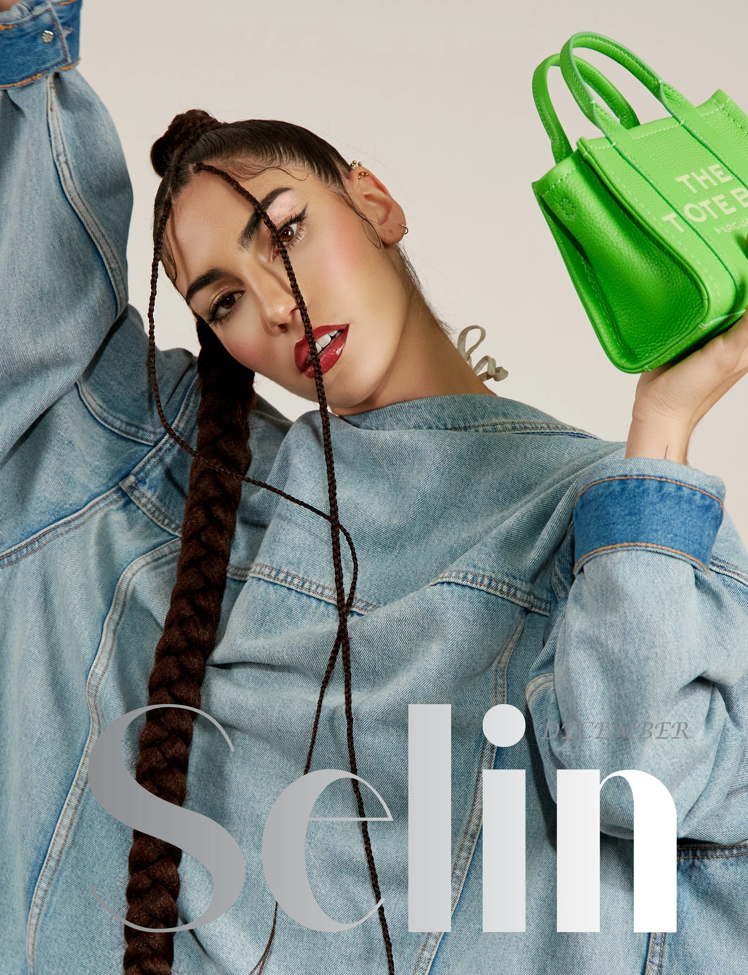 A woman with a long braided hairstyle wearing a denim jacket holding a bright green handbag, with the word 'September' visible on the magazine cover in the background.